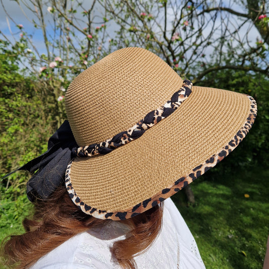 Natural Biscuit coloured open backed hat with an animal print trim and black bow.