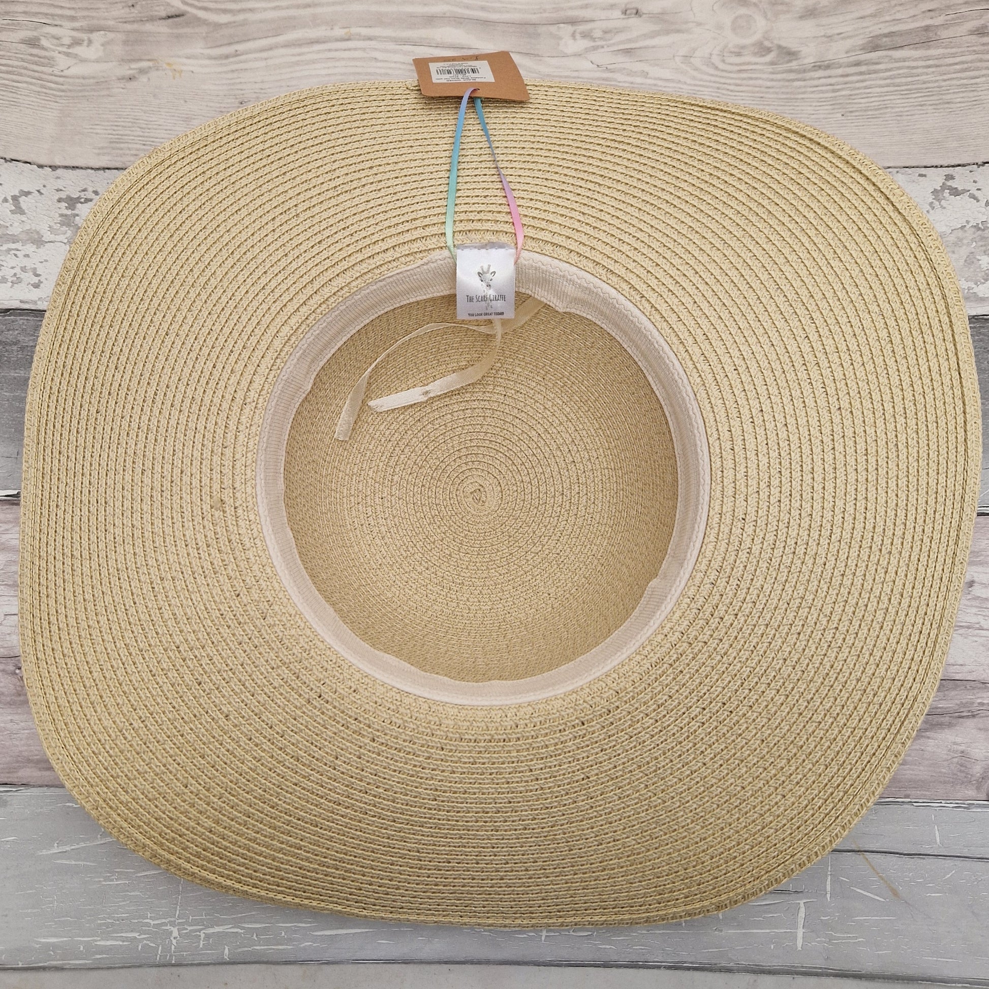 Inside view of a natural coloured wide brimmed hat showing an adjustable head band on the inside of the crown.