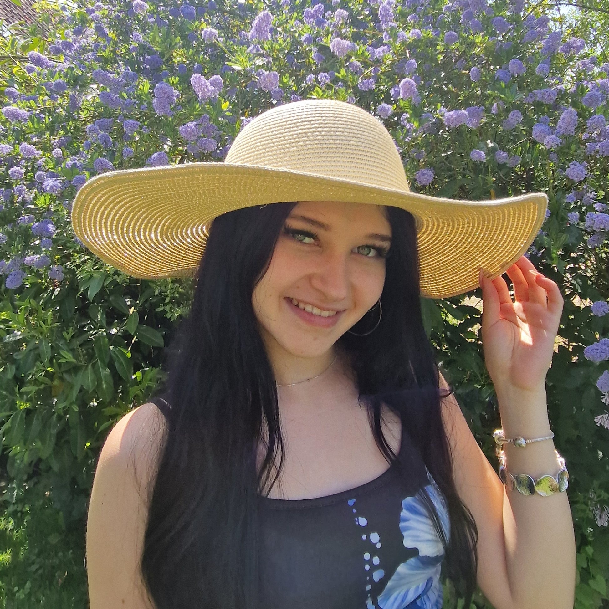 Young woman wearing a natural coloured wide brimmed hat.