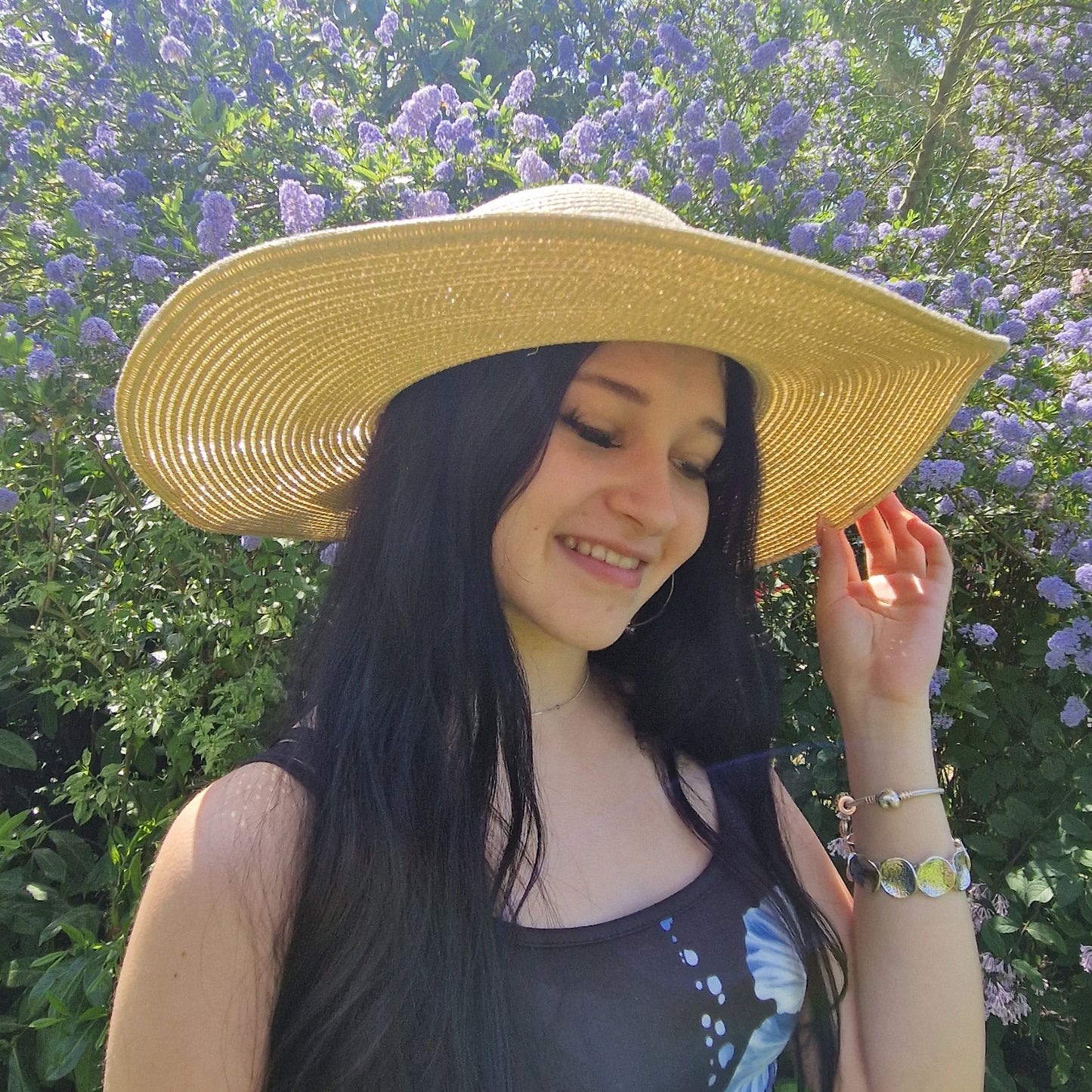 Young woman wearing a natural coloured wide brimmed hat.