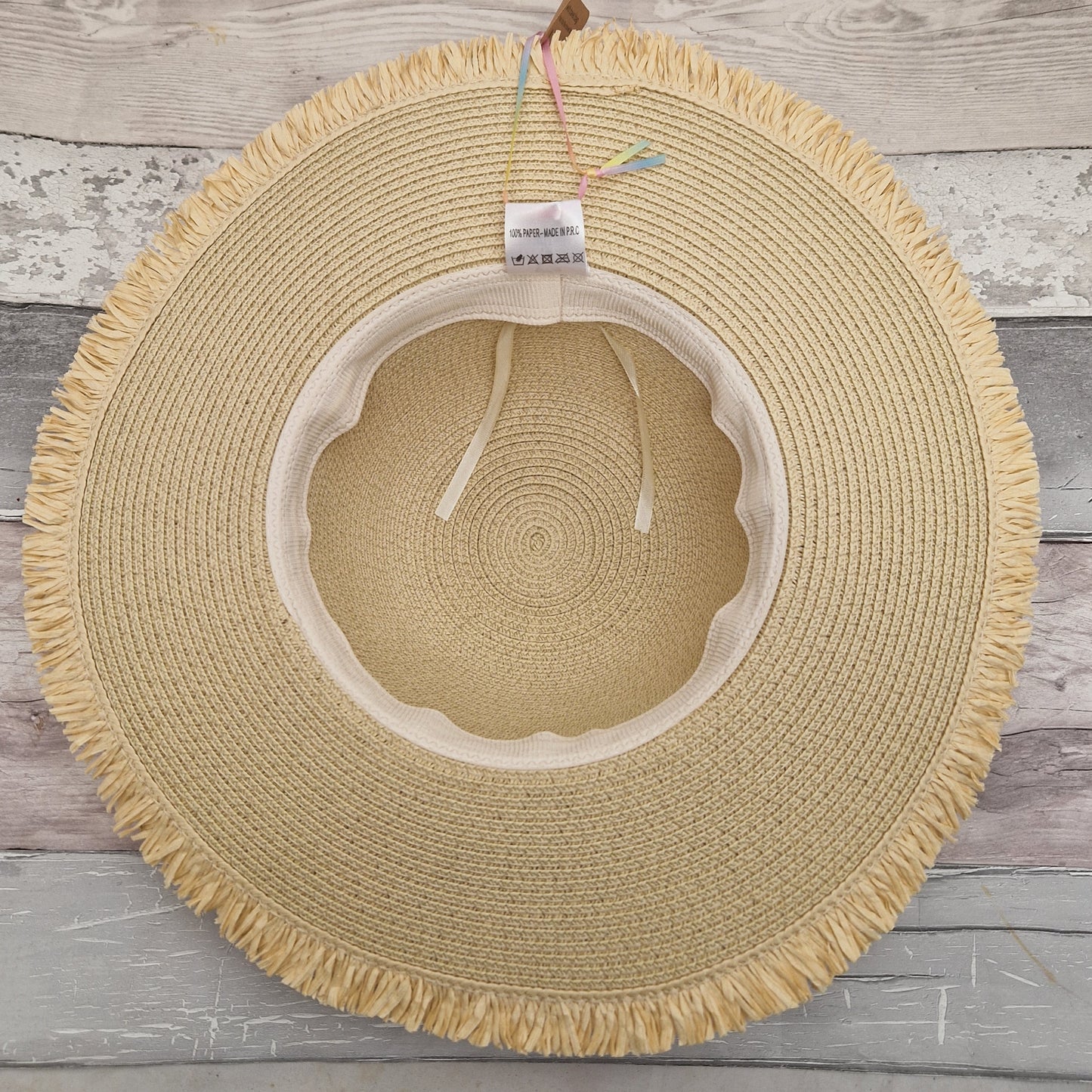 Inside view of a natural wide brimmed hat. Inside the crown is an adjustable head band and label.