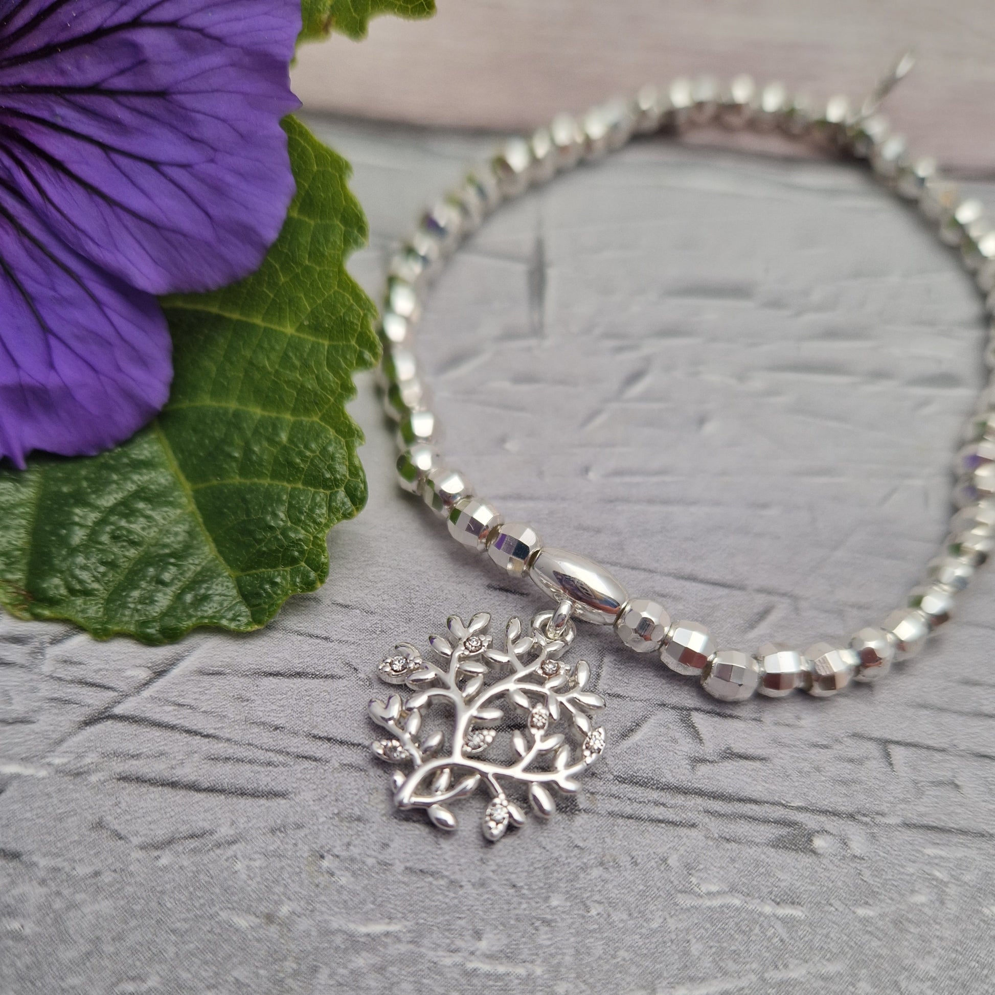 Silver beaded bracelet decorated with a Tree of Life Charm.