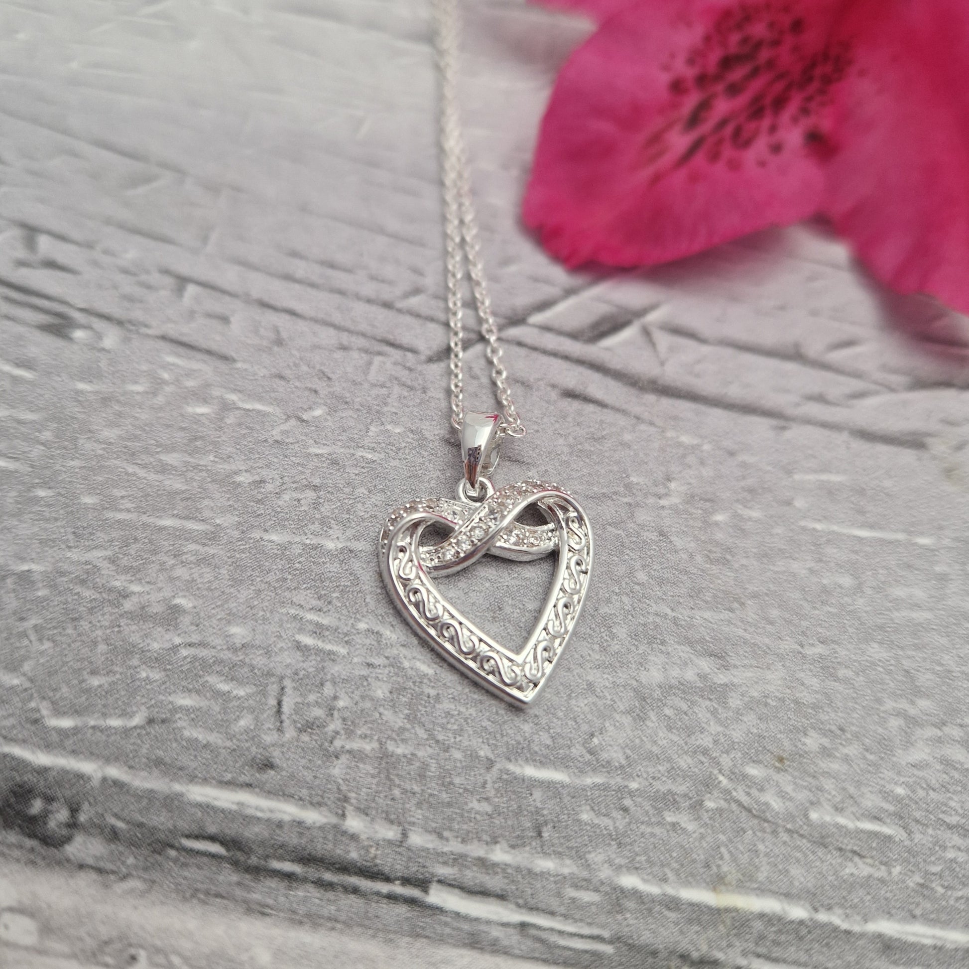 Twisted love heart pendant on a silver plated necklace.
