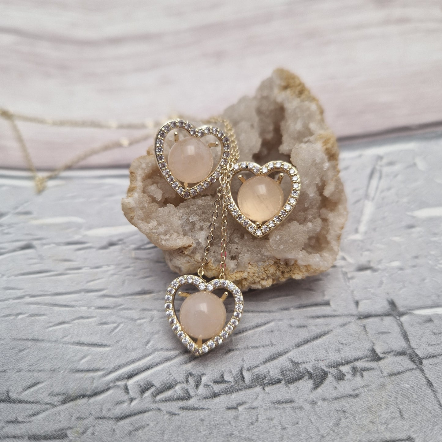 Rose quartz set in a love heart pendant and earrings on gold colouredmounts.