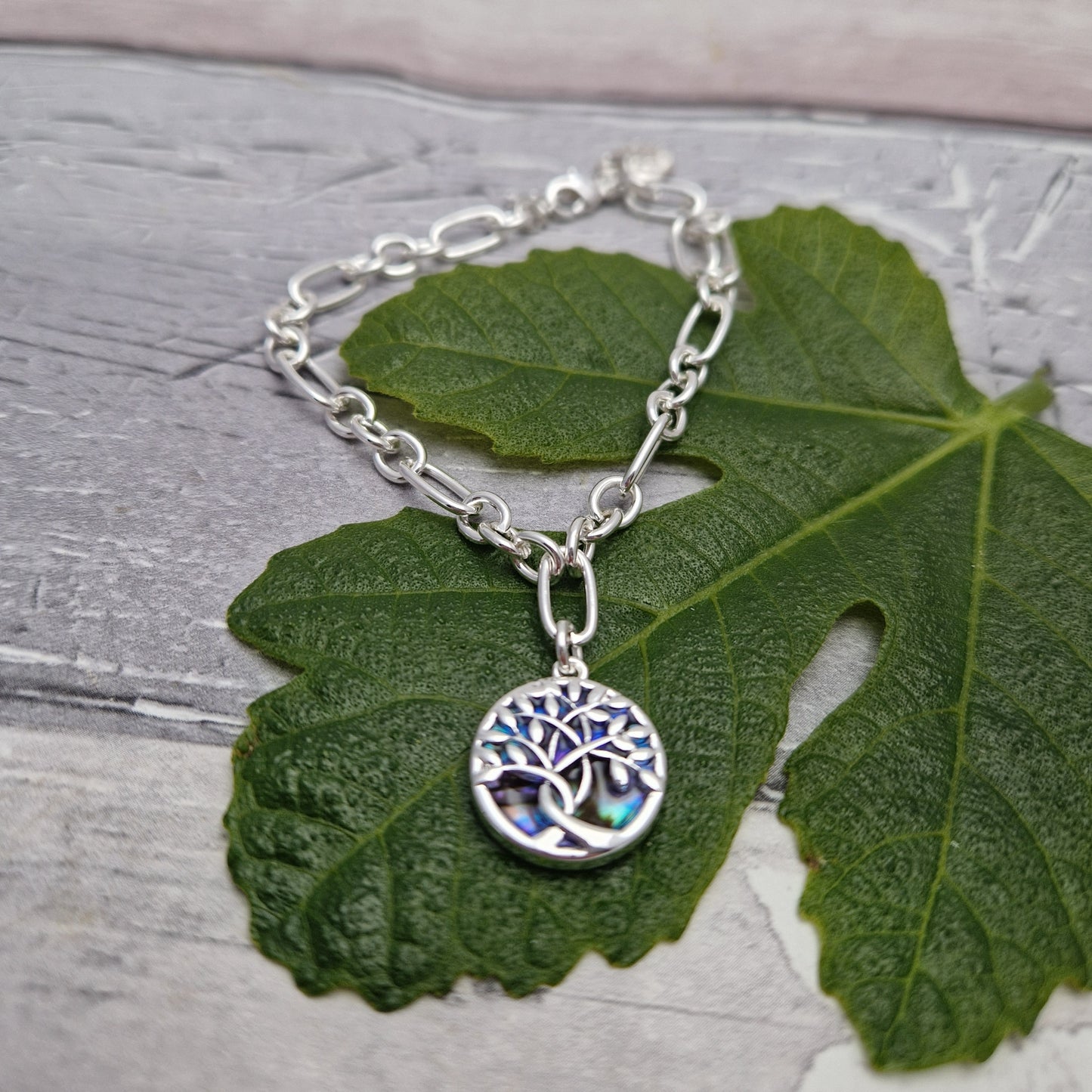 Bracelet with a Paua shell charm decorated with a tree of life. 