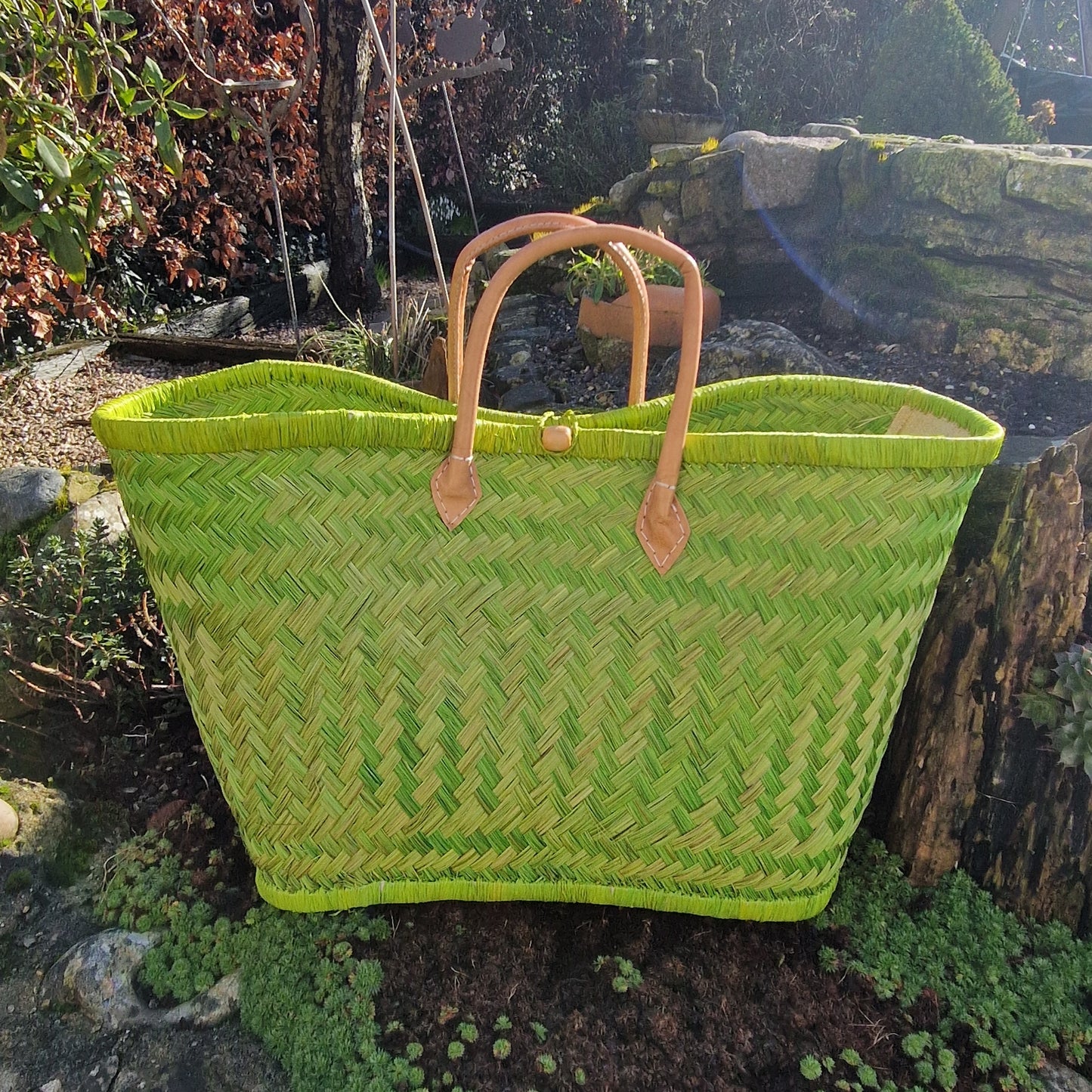 Lime Green woven basket with leather handles and a toggle closer.