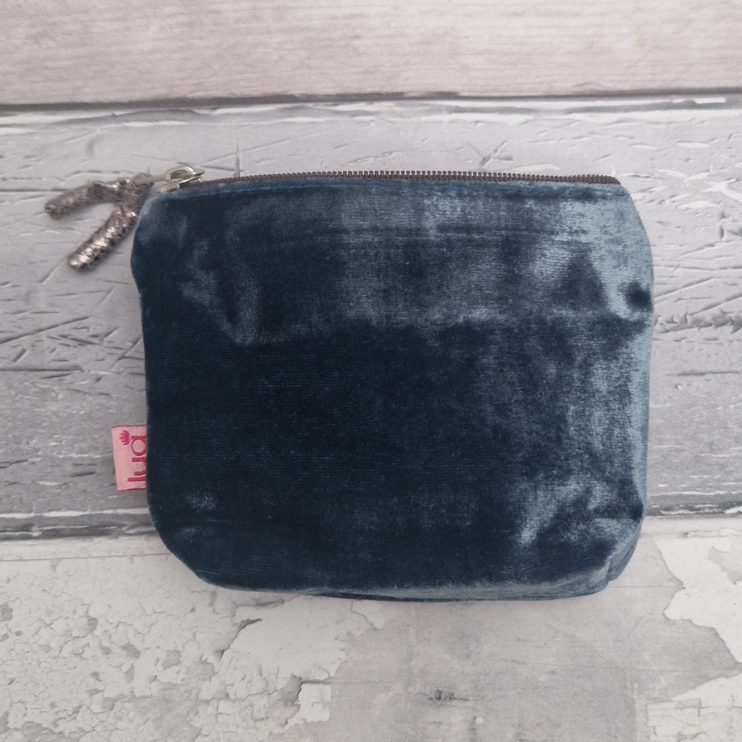 Blue velvet pouch on a textured gray surface