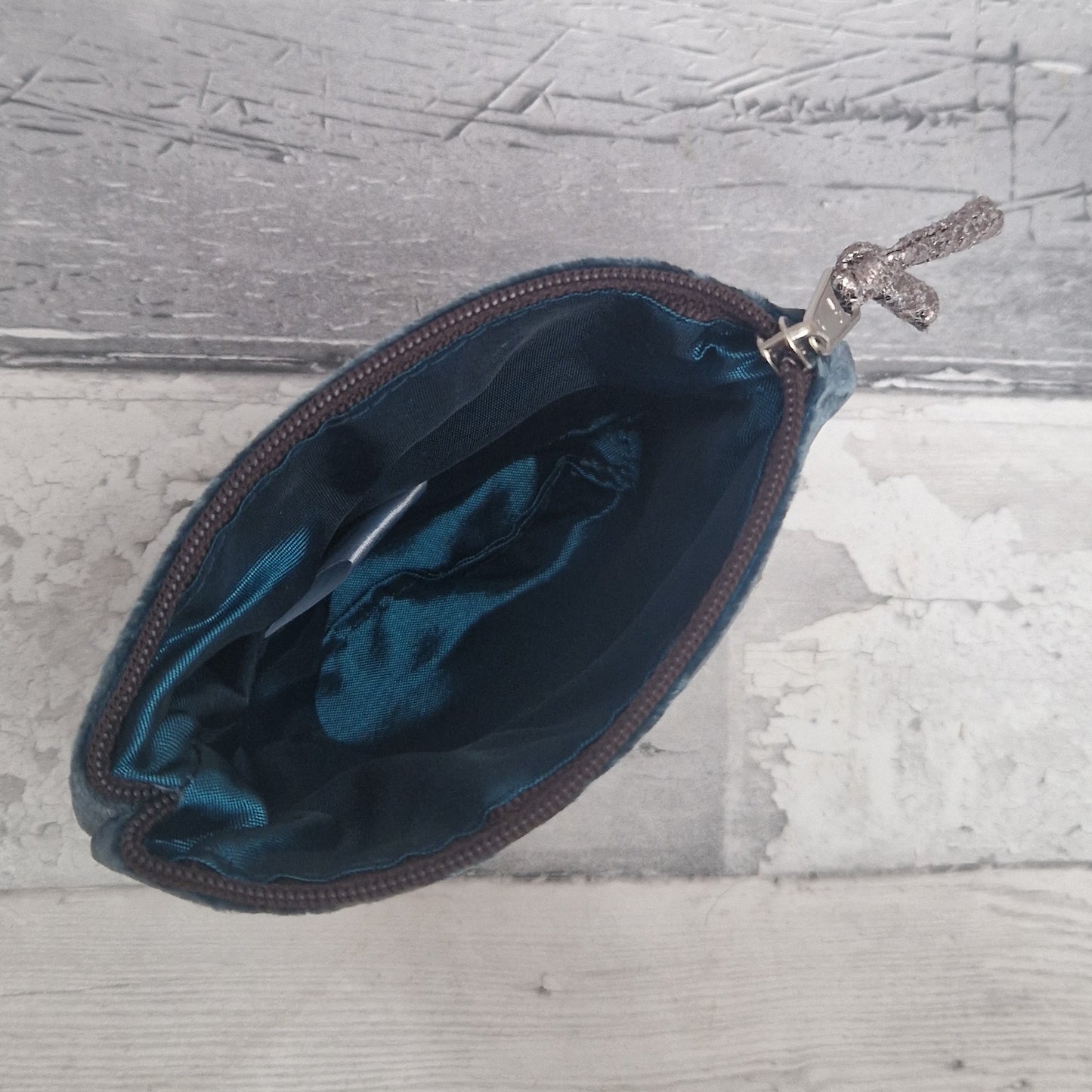 Blue pouch with a zipper on a textured gray surface