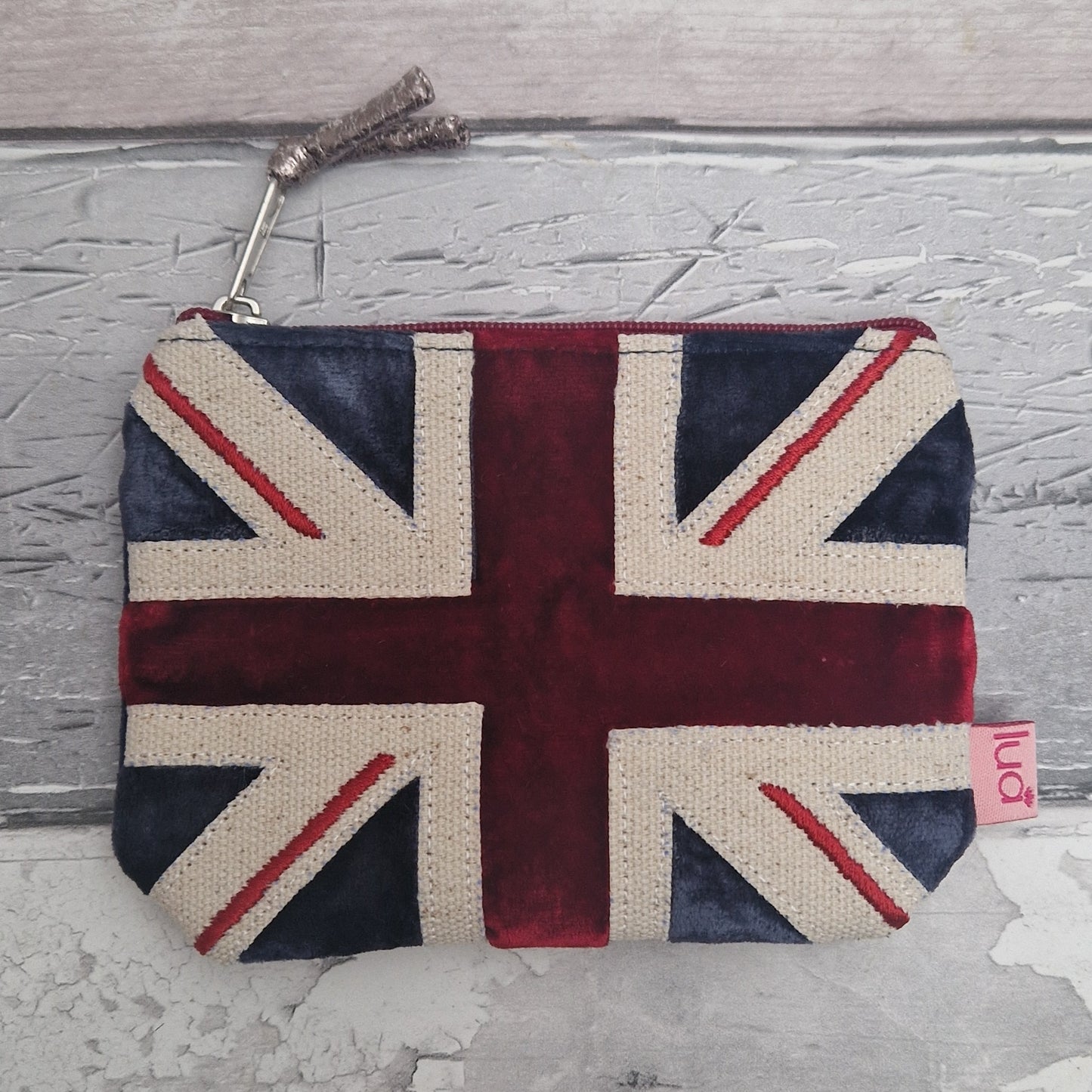 Purse with Union Jack design on a textured gray surface.