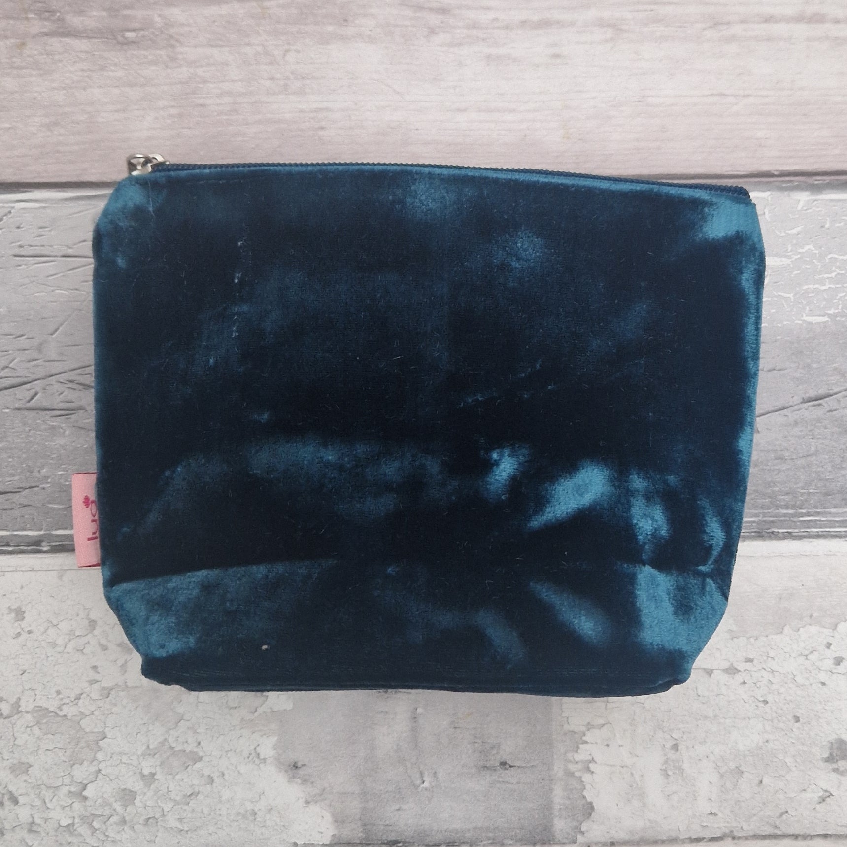 Blue velvet pouch on a gray wooden surface