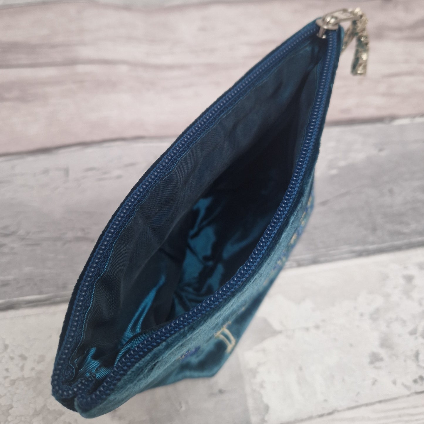 Blue pouch with a zipper on a wooden surface