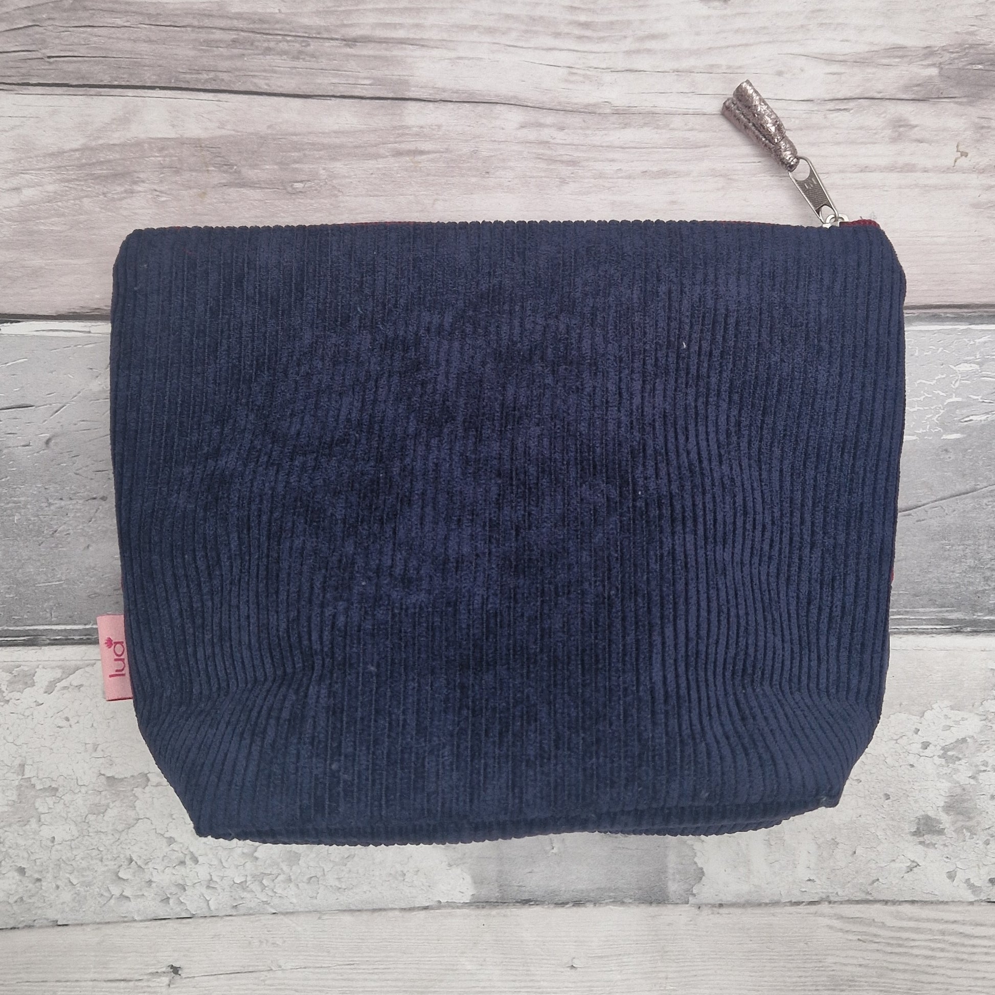Navy blue textured pouch on a wooden surface
