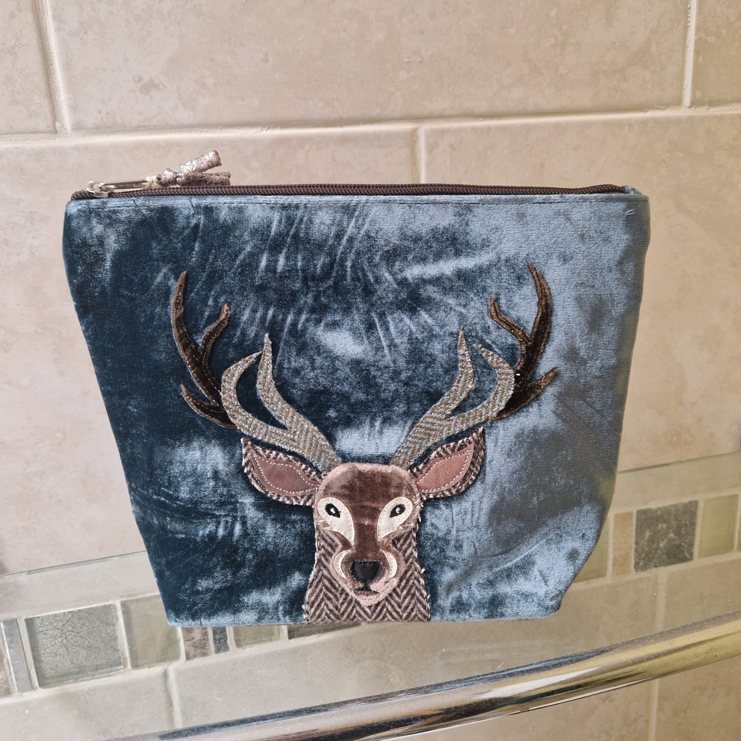 Blue velvet pouch with Highland Stag design on a tiled surface