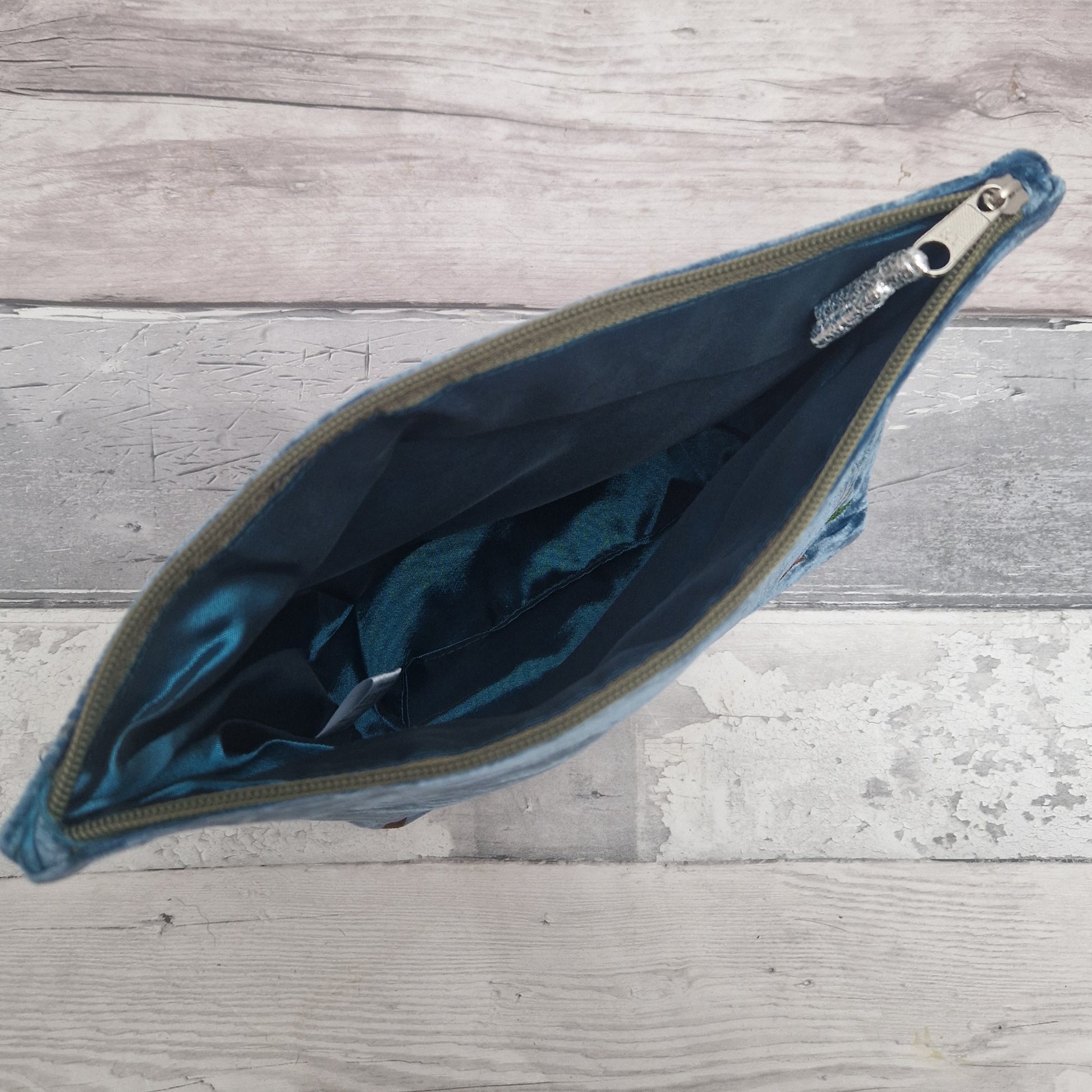 Blue pouch with a zipper on a wooden surface