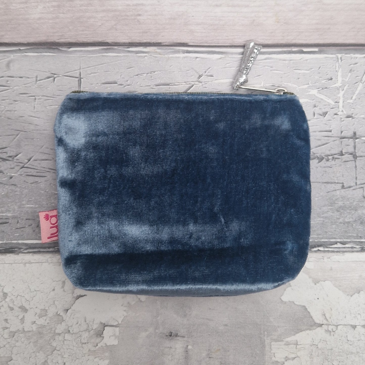 Blue velvet pouch on a textured gray surface