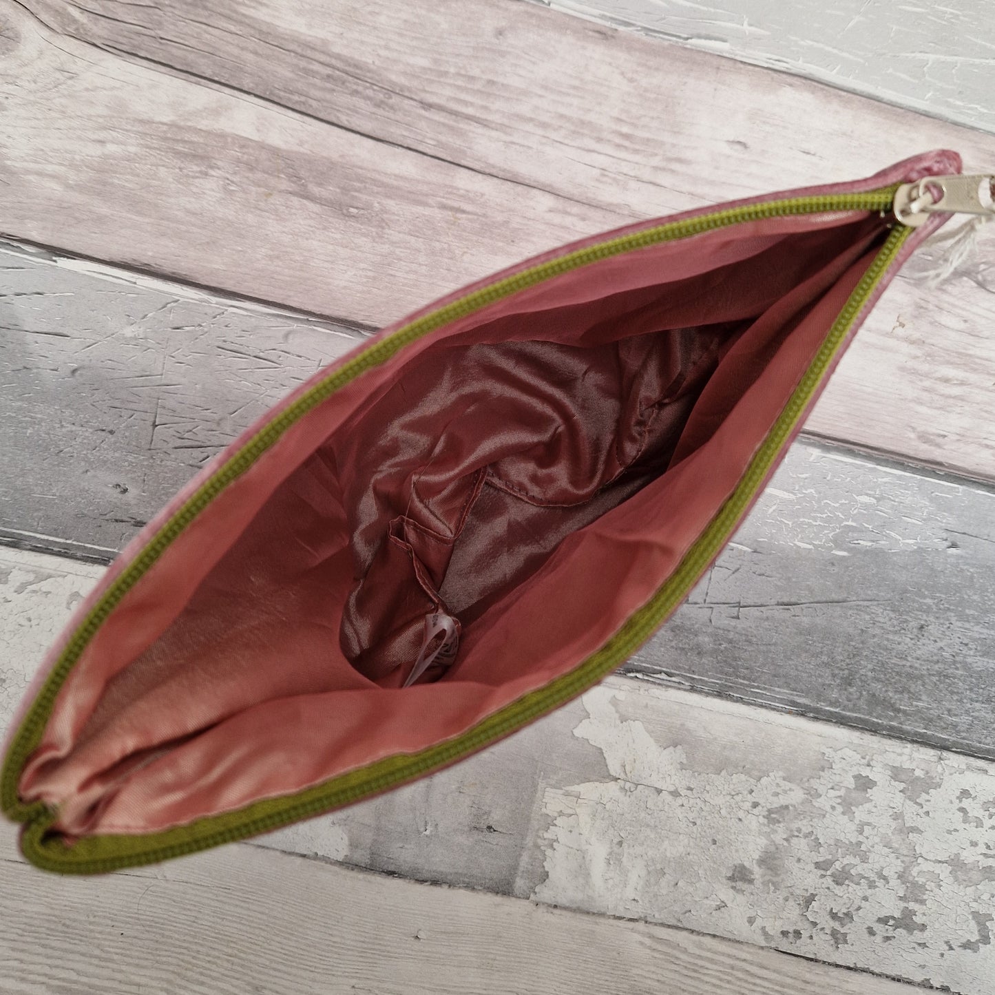 Inside view of a silk lined velvet bag with a green zipper.