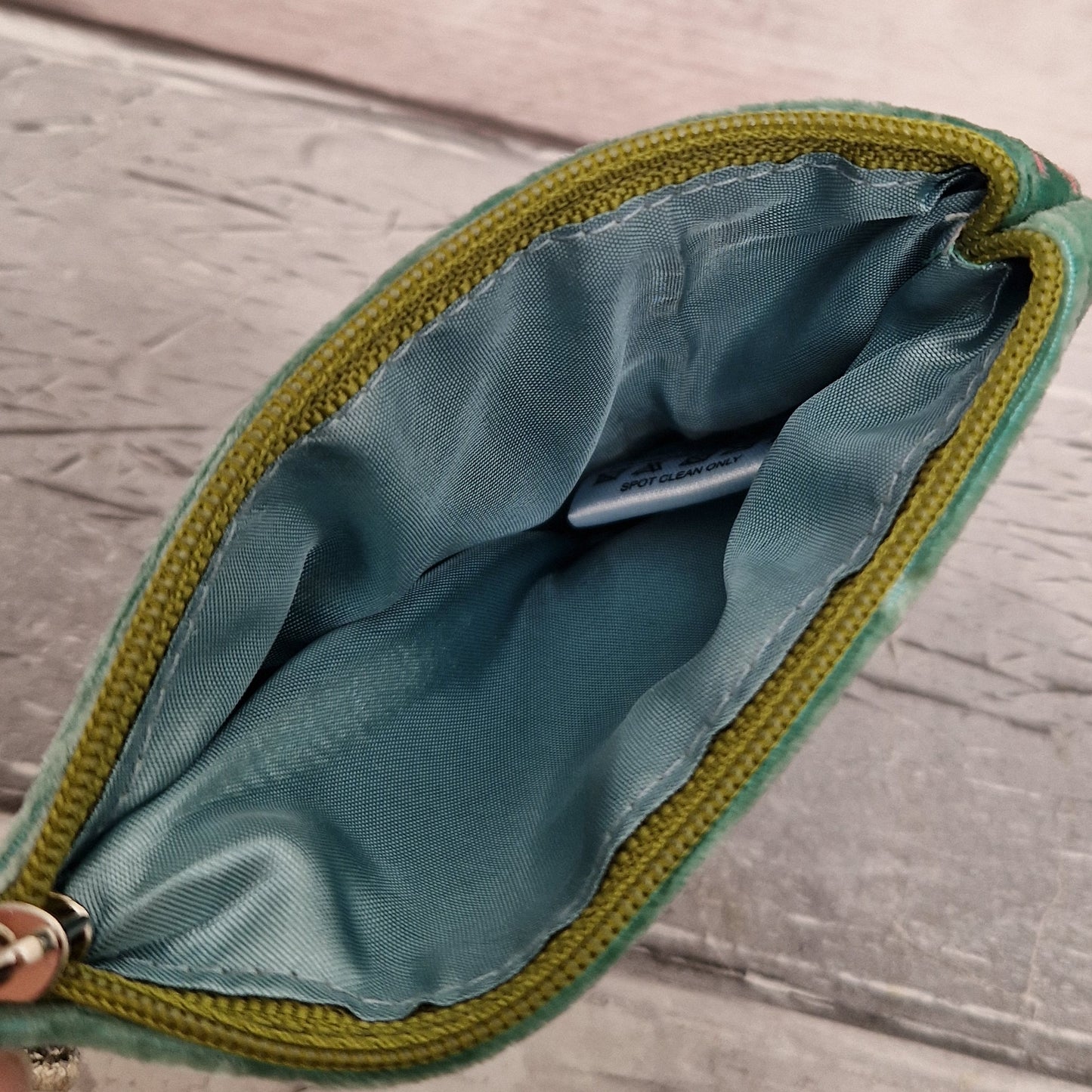 Inside view of a silk lined coin purse with a green zipper.