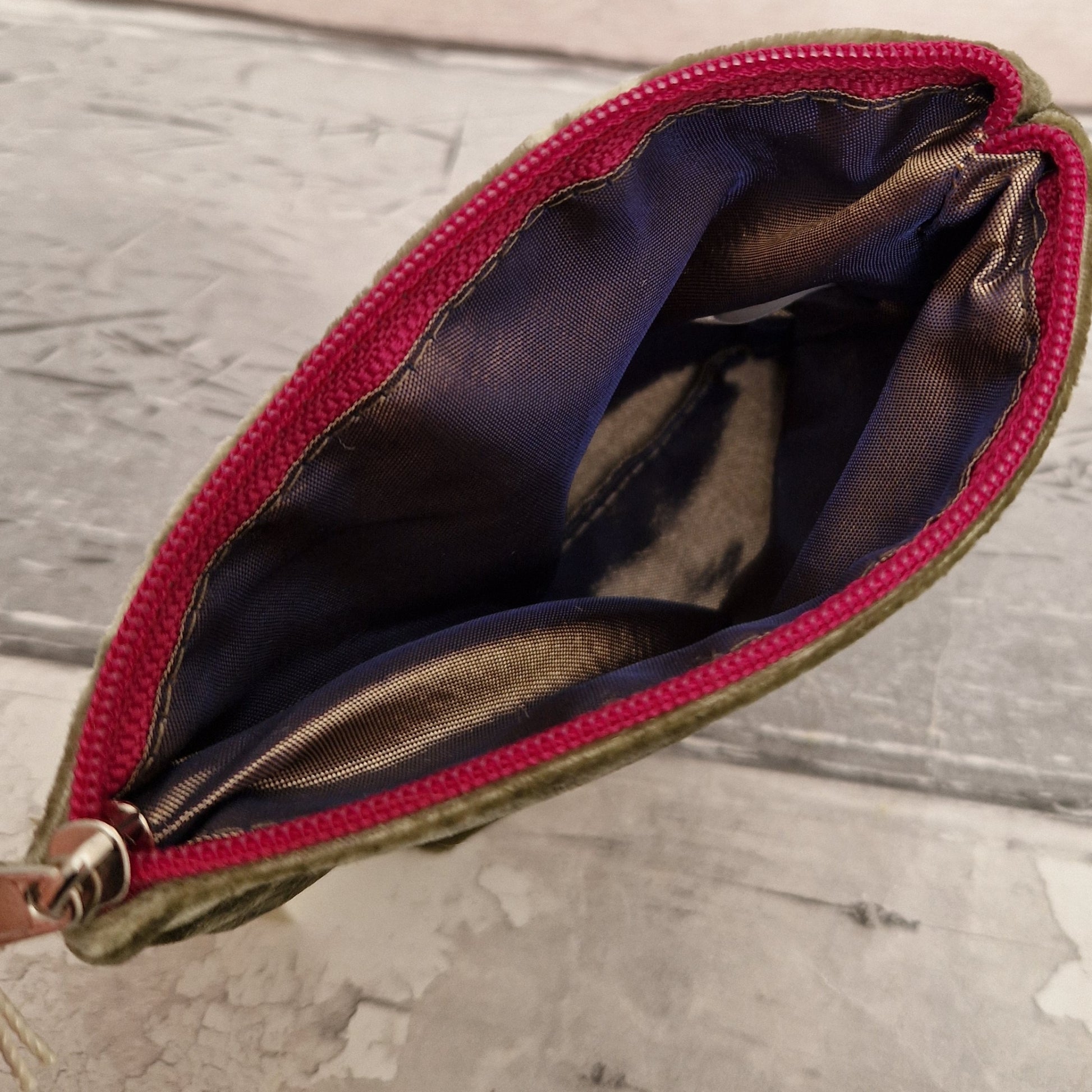 Inside view of a silk lined coin purse with a pink zipper.