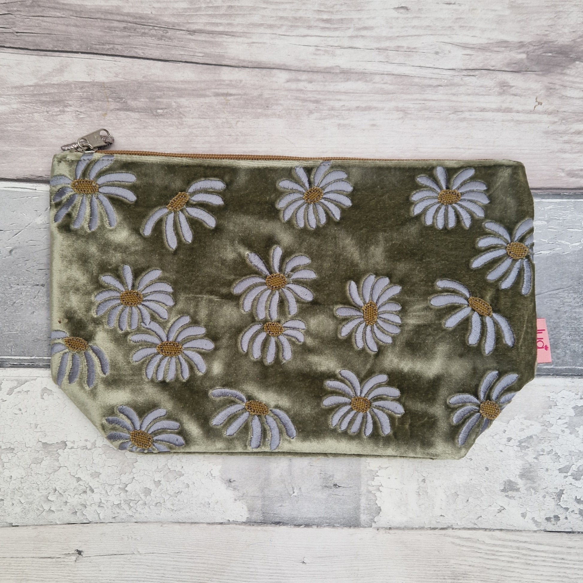 Fennel green velvet pouch decorated with embroidered daisies.