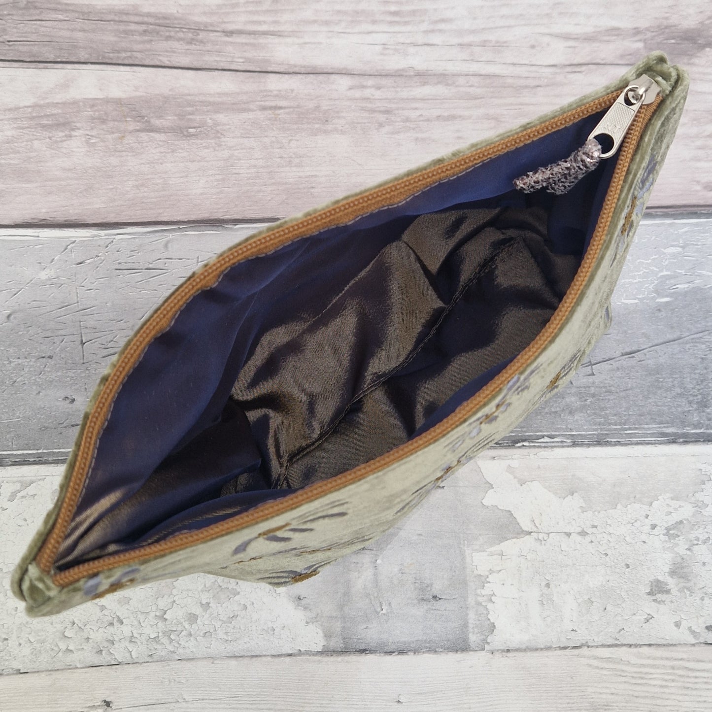 Inside view of the fennel green daisy velvet pouch revealing a metallic iridescent mustard silk lining.
