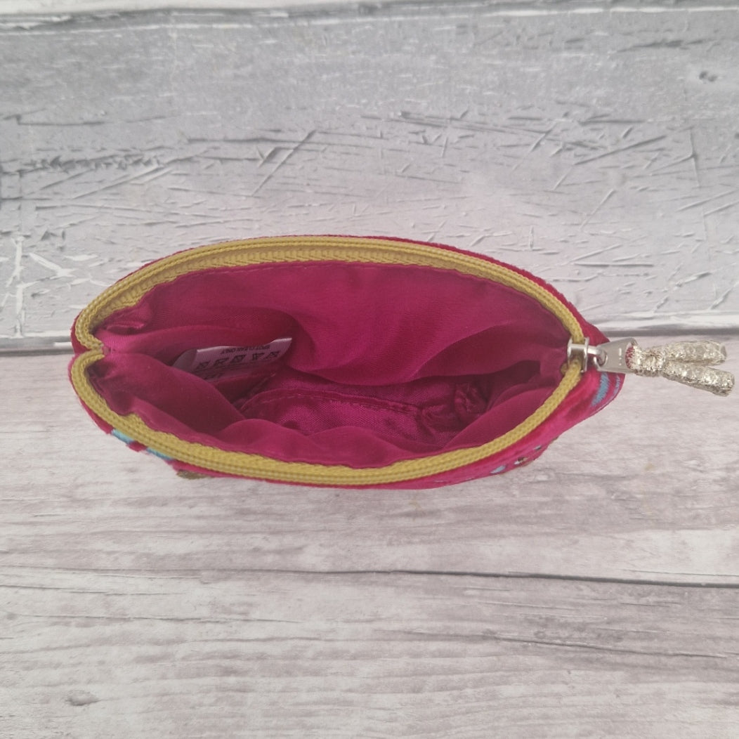 Inside view of a hot pink coin purse showing a matching pink silk lining.