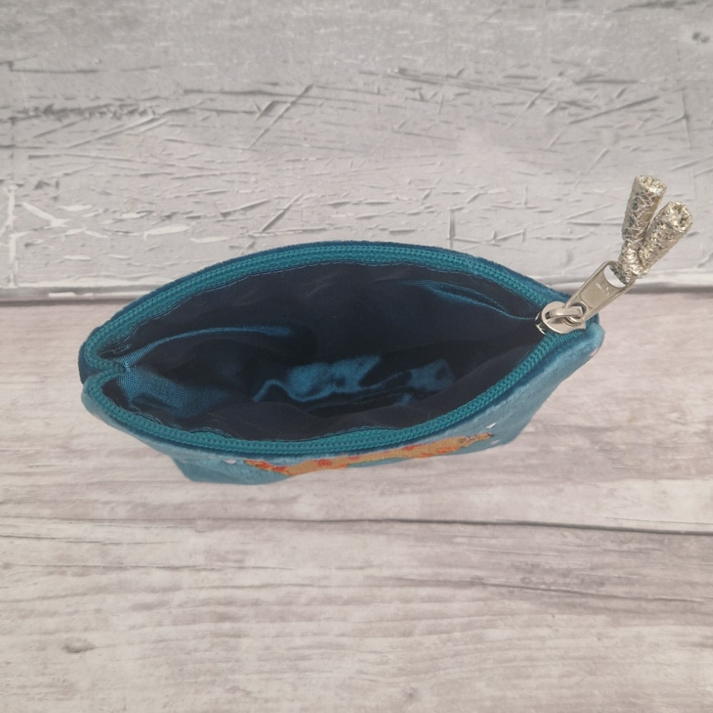 Inside view of a coin purse showing a turquoise blue silk lining.