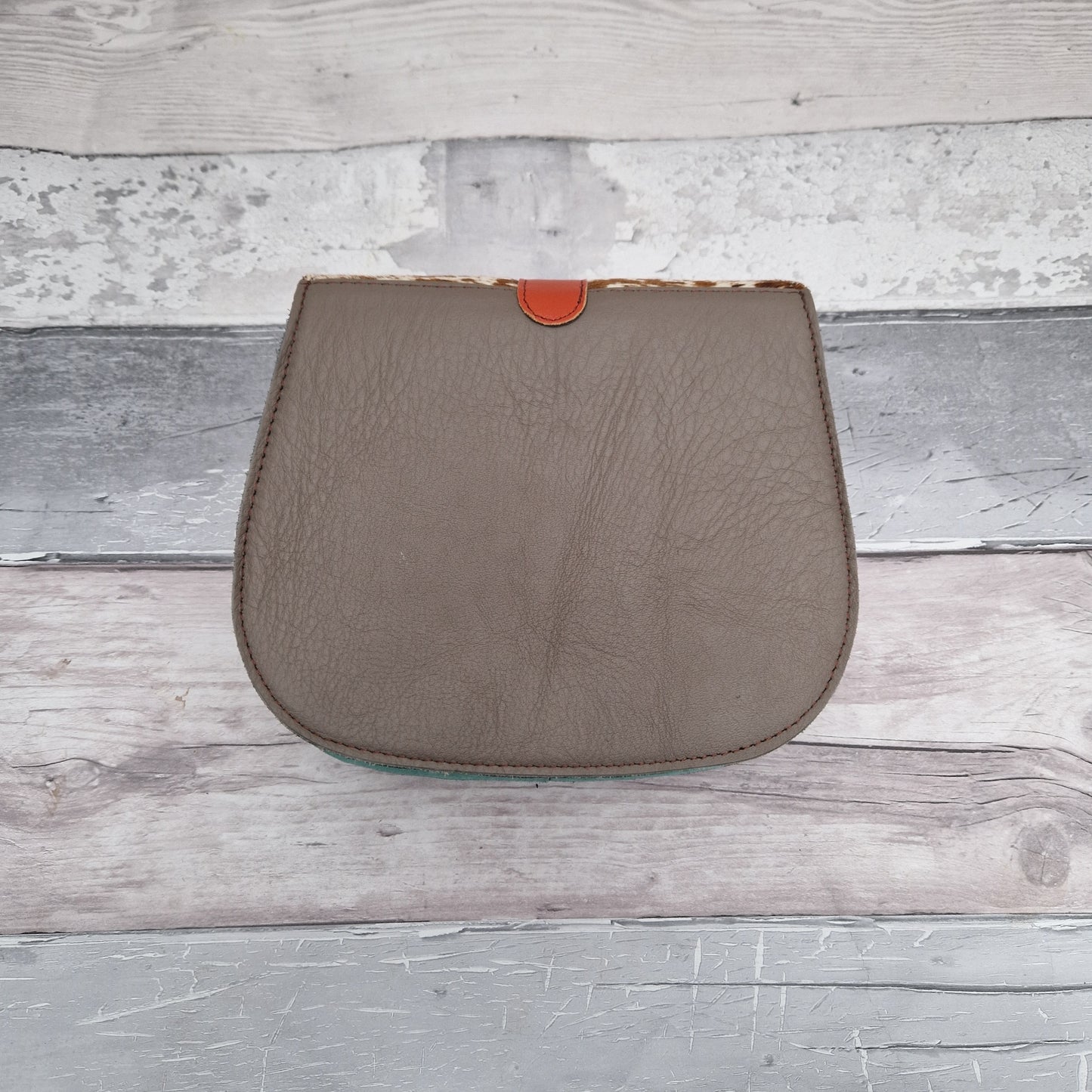 Bag made entirely from leather off cuts in a rainbow of colours with a textured panel in cow print.