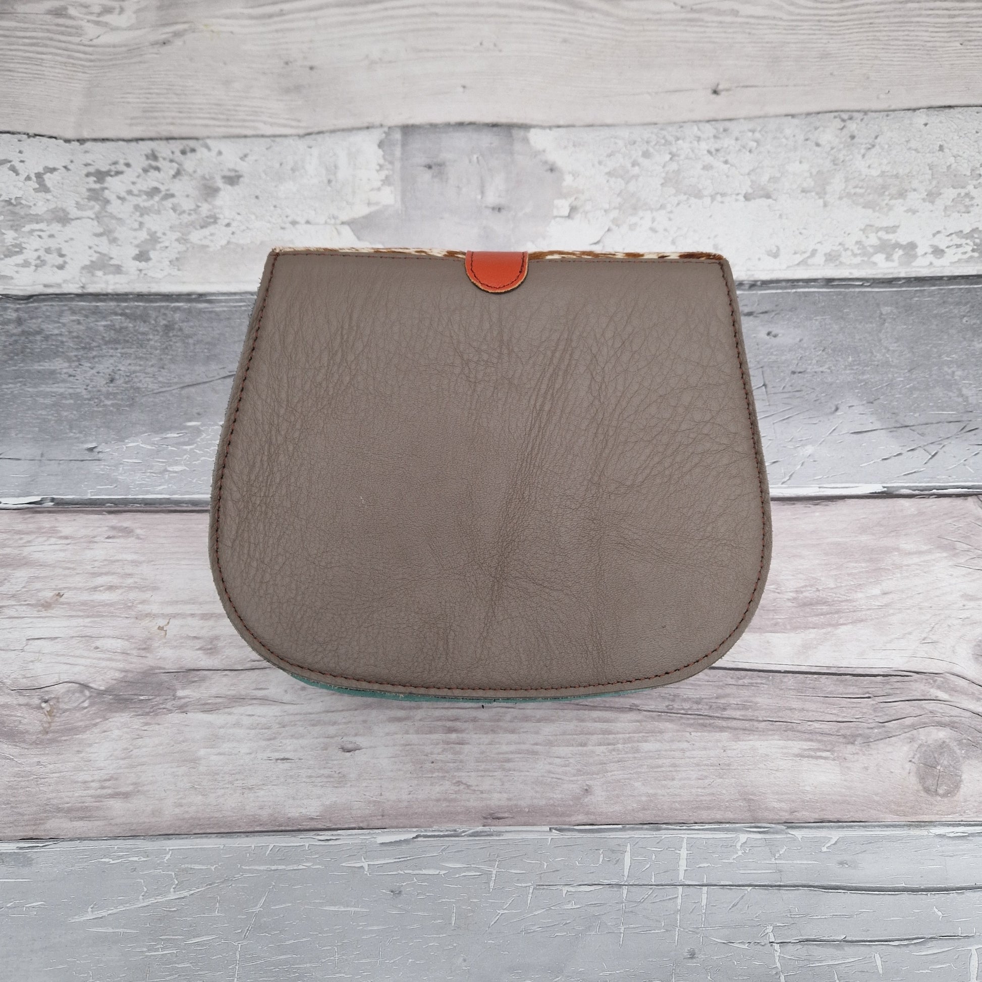 Bag made entirely from leather off cuts in a rainbow of colours with a textured panel in cow print.