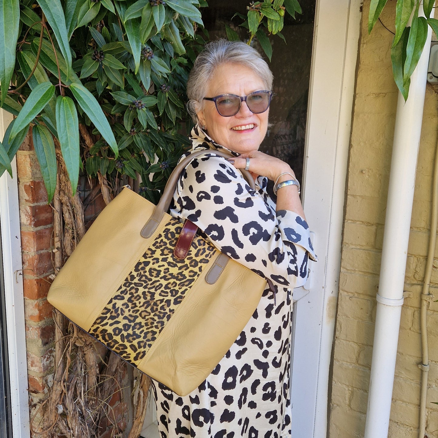 Gold leather tote bag with leopard print panel.
