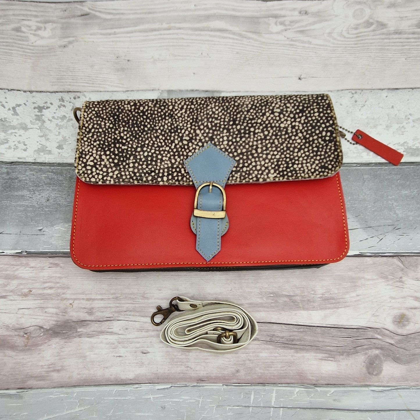 Stunning red leather bag with a textured panel in black with white micro spots.
