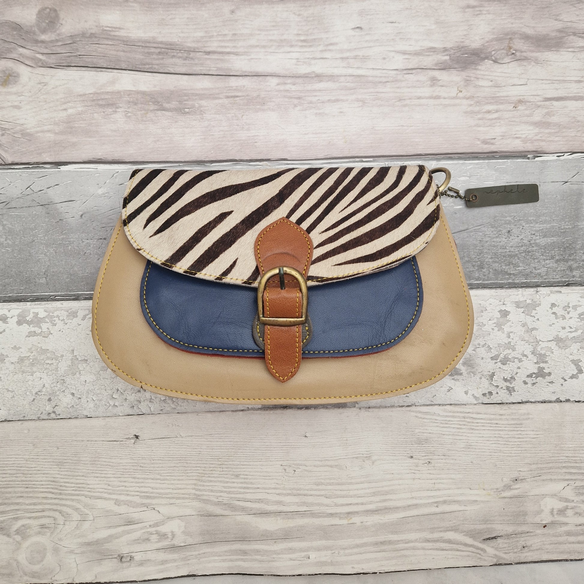 Matte gold leather bag with textured zebra print panel.