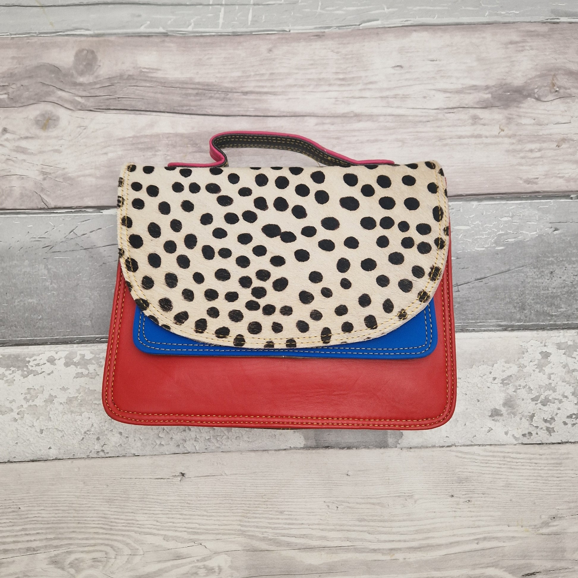 Red leather bag with a textured spot print panel.