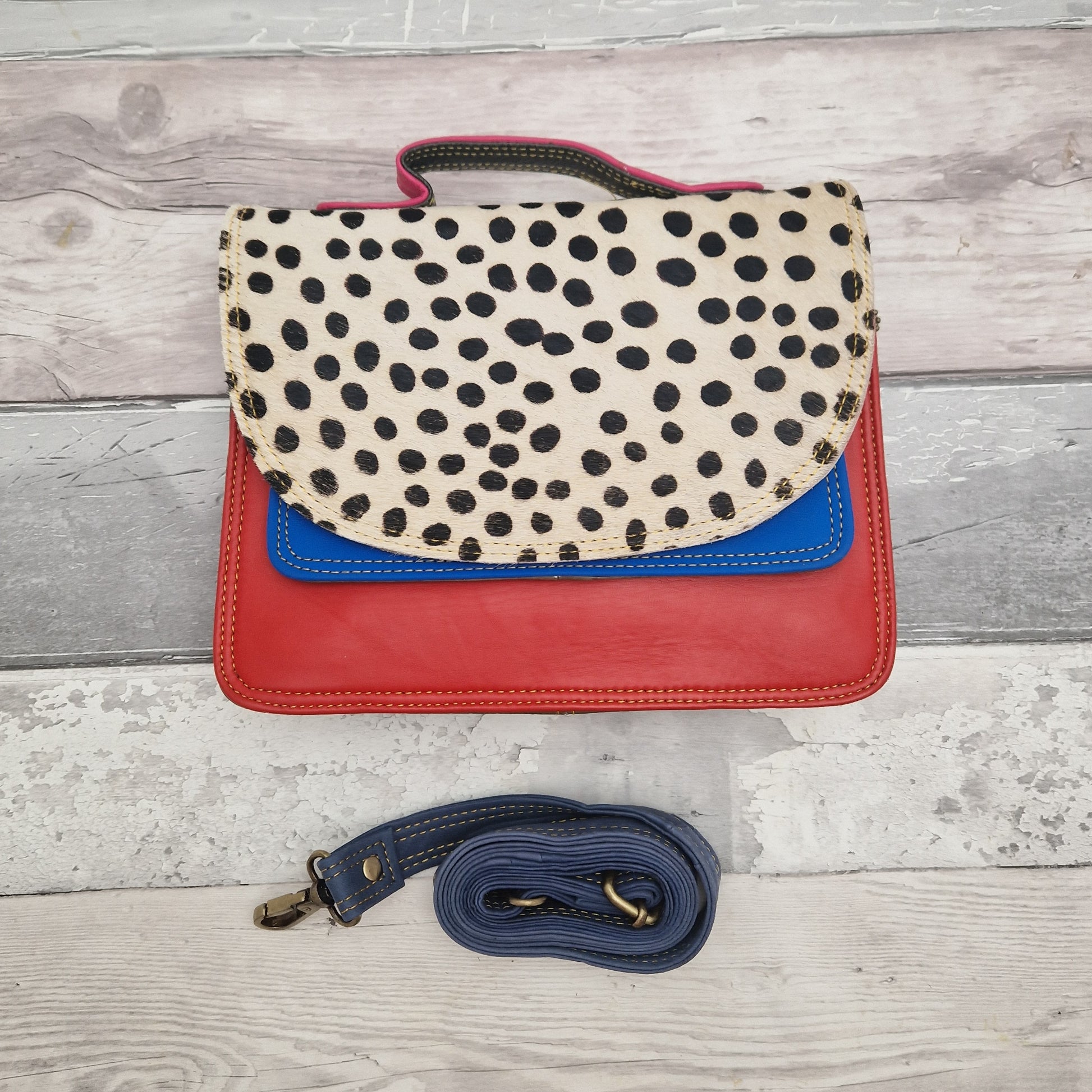 Red leather bag with a textured spot print panel.