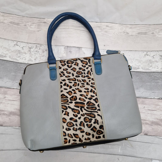 Grey leather handbag with blue handles and a textured leopard print panel.