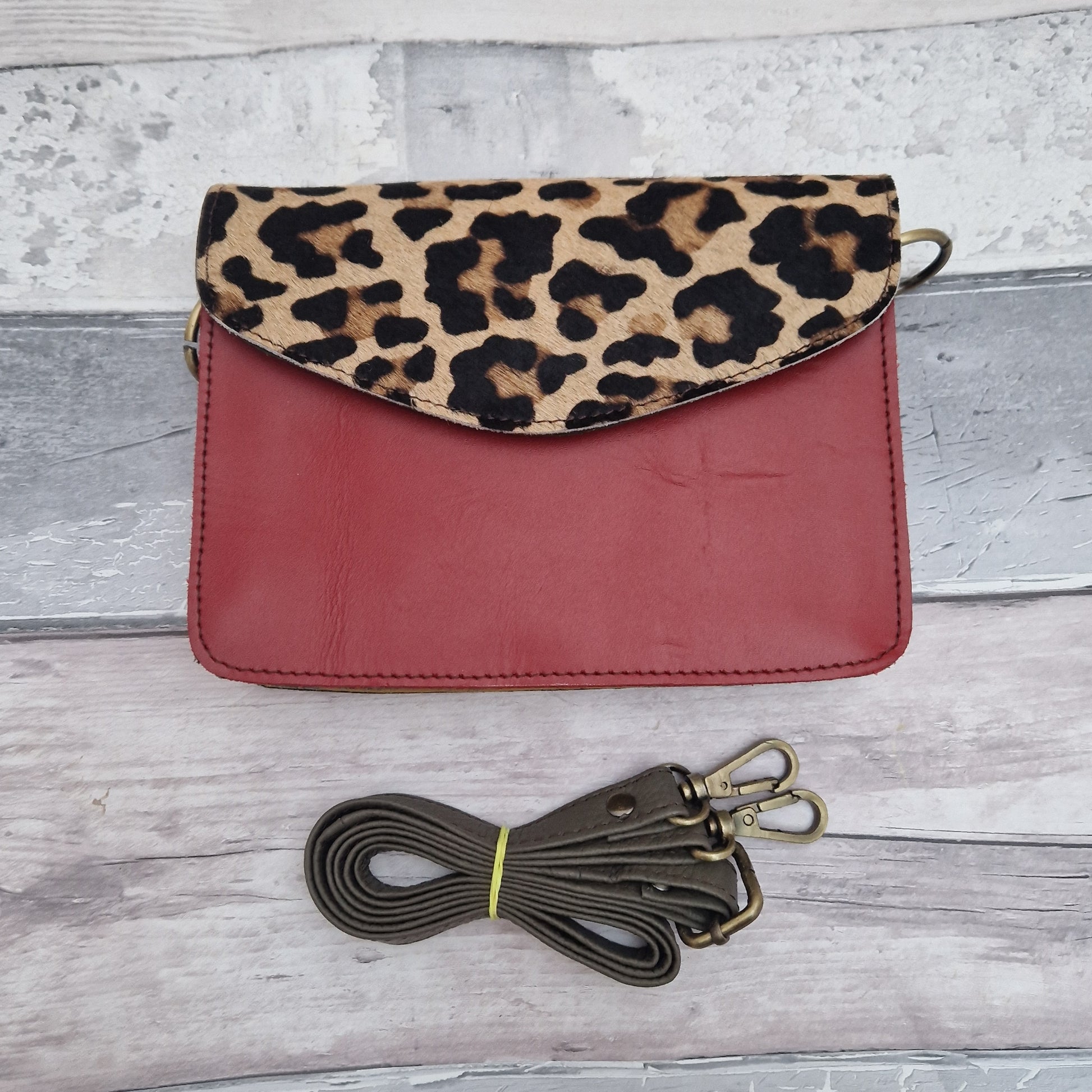 Red leather envelope style bag with a leopard print panel.