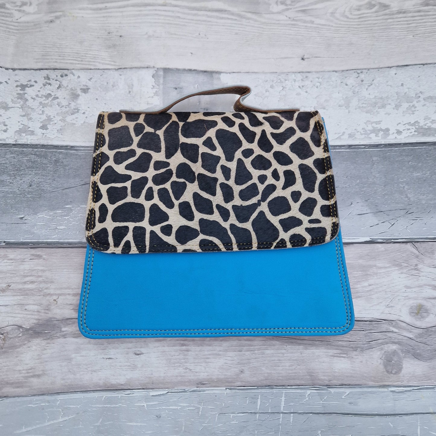 Bright Blue leather bag with a textured front panel in a giraffe print.
