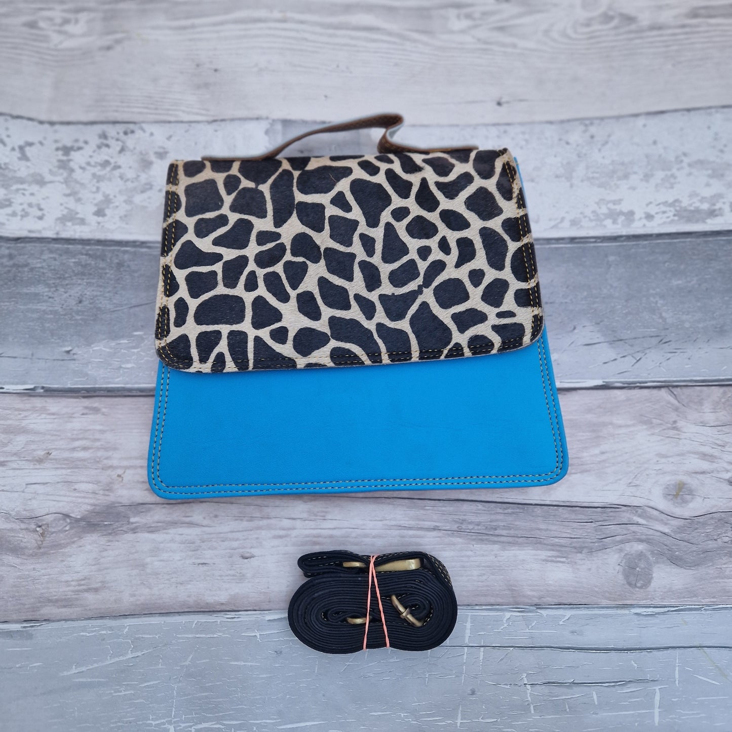 Bright Blue leather bag with a textured front panel in a giraffe print.