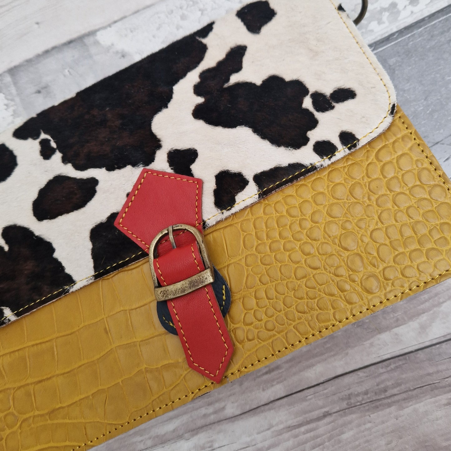 Mustard coloured leather bag with a textured panel of cow hide.