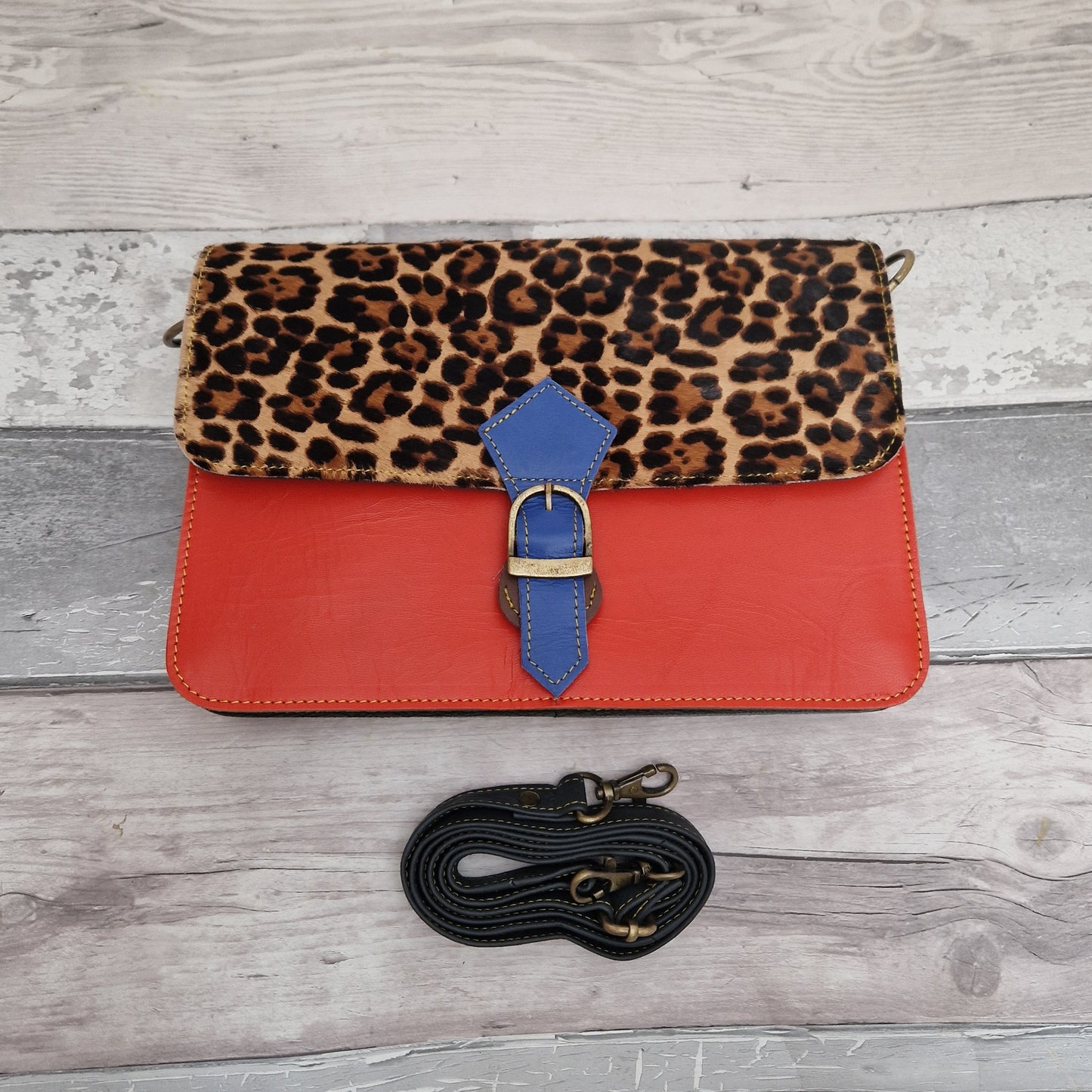 Vivid Orange Leather Bag with a textured leopard print front panel.