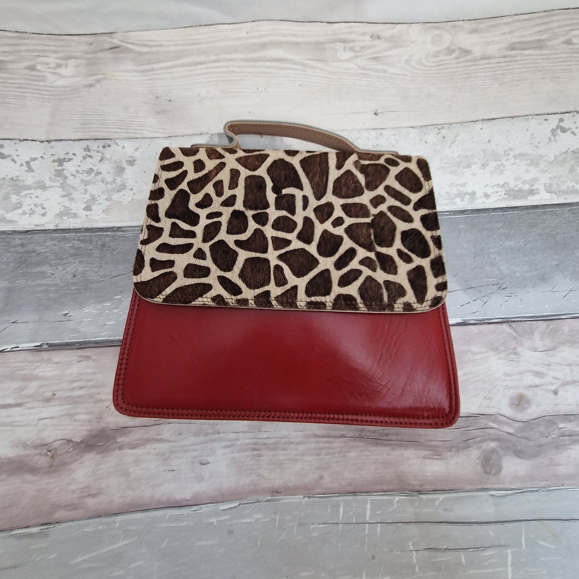 Dark Red leather bag with a textured panel in a giraffe print.