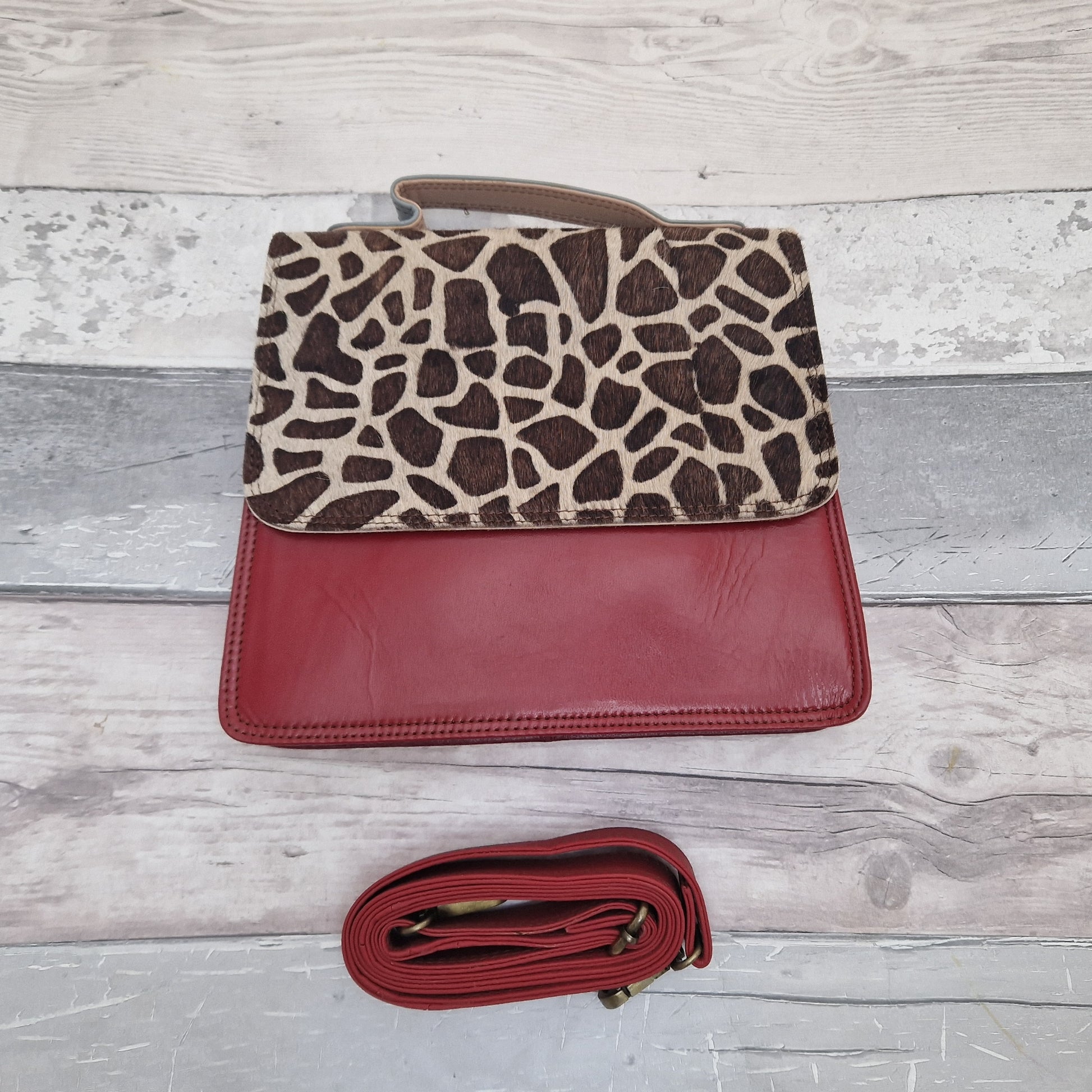 Dark Red leather bag with a textured panel in a giraffe print.