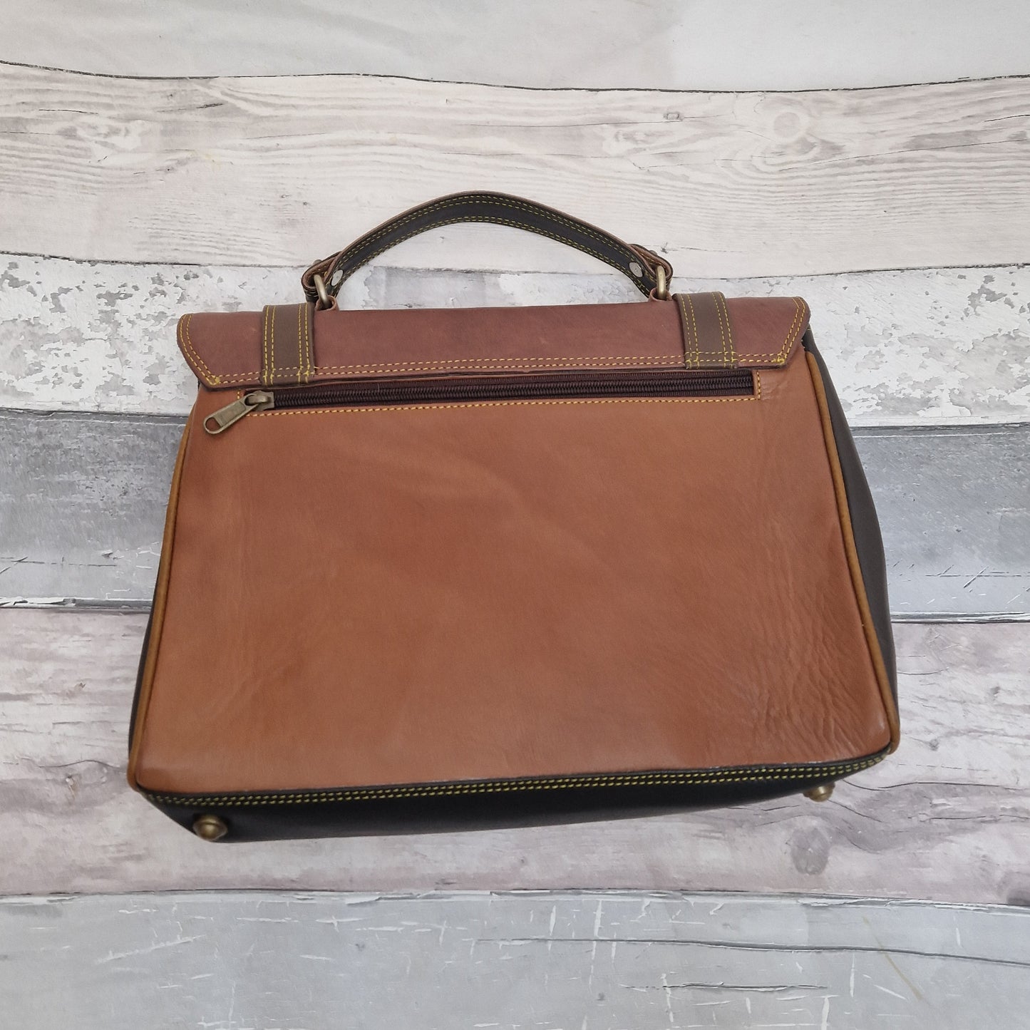 Satchel style leather bag in mulitple shades of brown, finished with brass fixings and buckles.