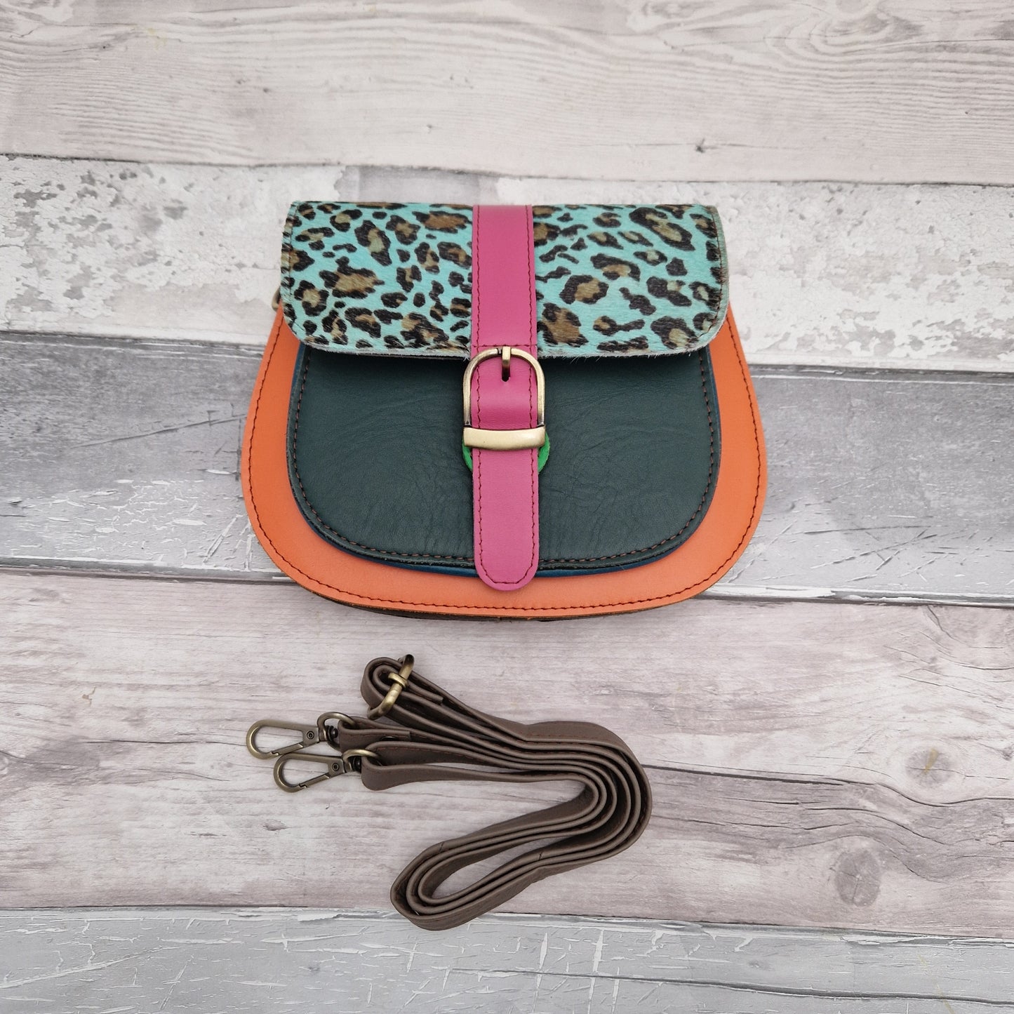 Saddle bag style, made from leather off cuts in bright colours with a textured panel of leopard print in blue.