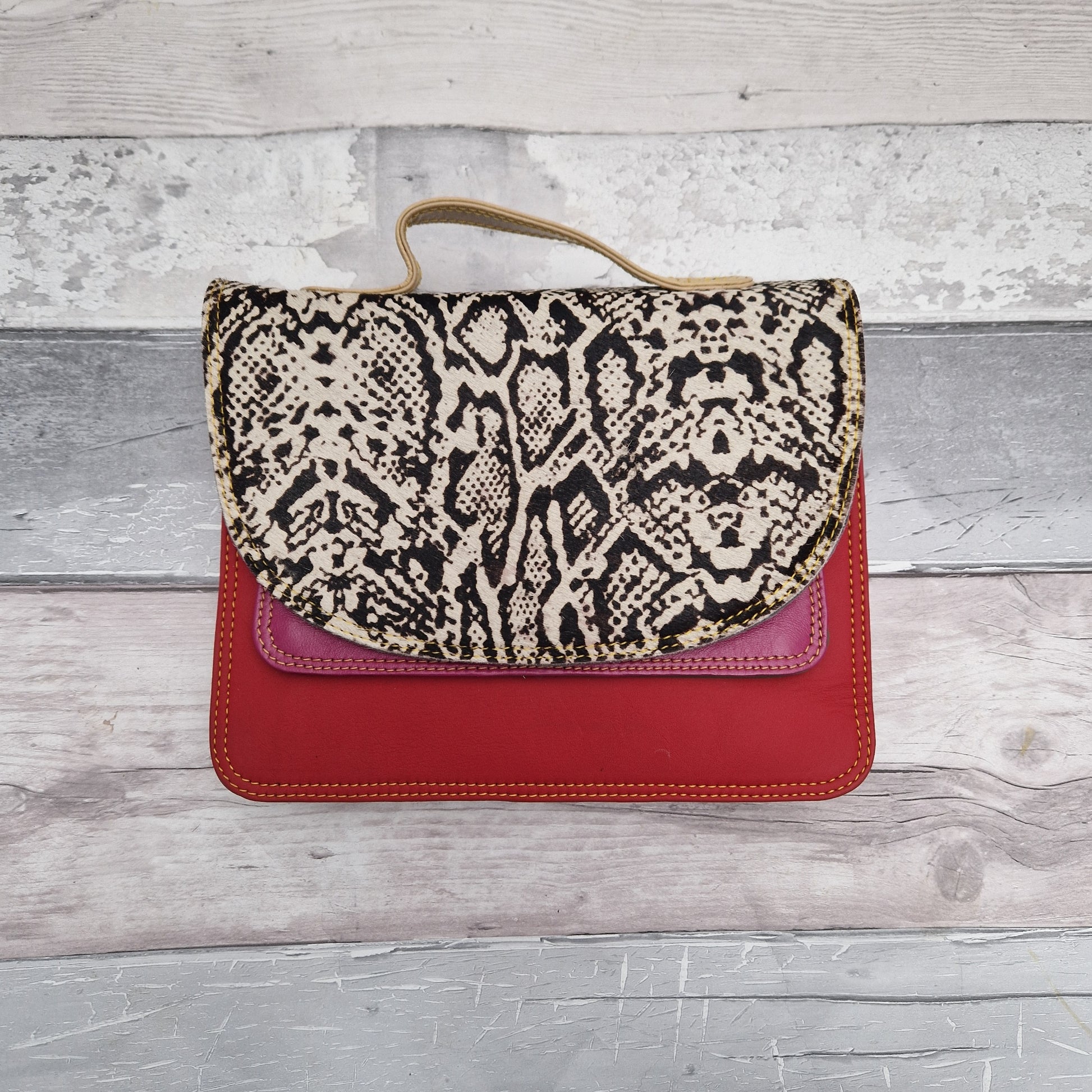 Red leather bag with a large snake skin patterned panel.