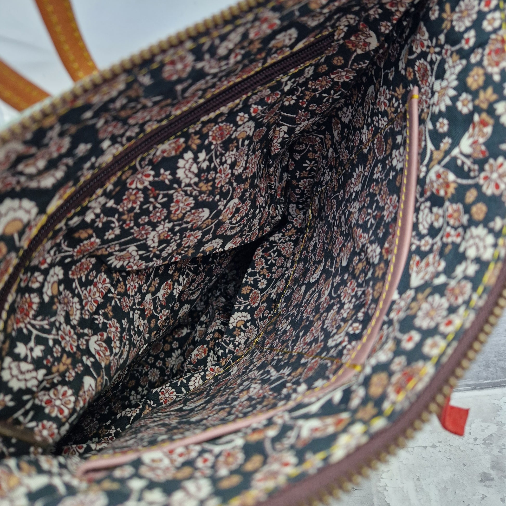 Floral lined interior of leather back pack.