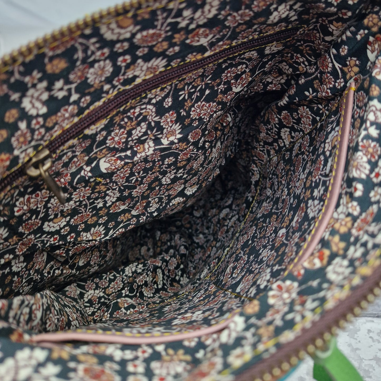 Floral lined interior of leather back pack.