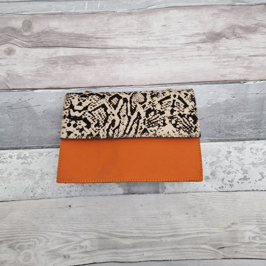Orange Leather bag with a snake print panel in black and white.