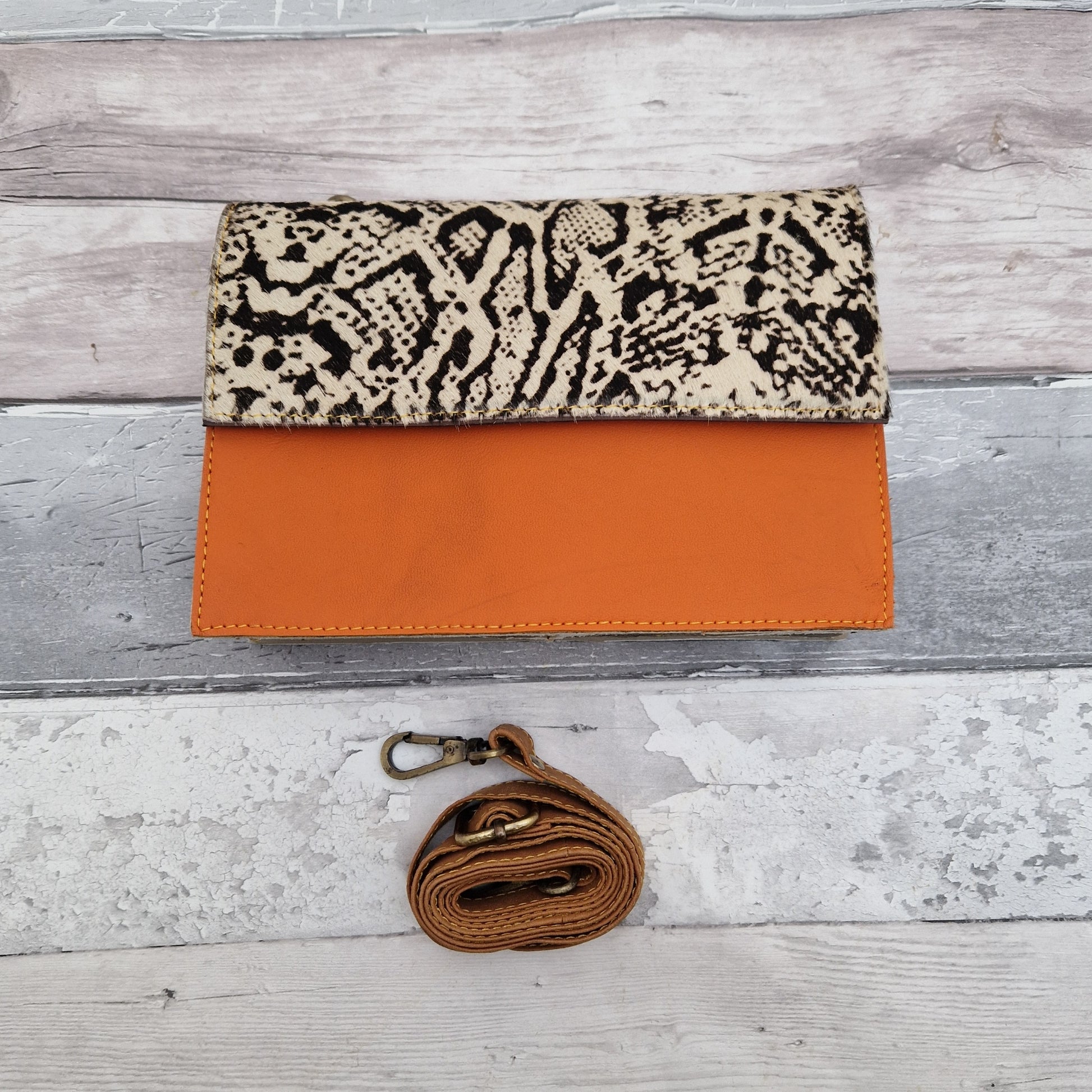 Orange Leather bag with a snake print panel in black and white.