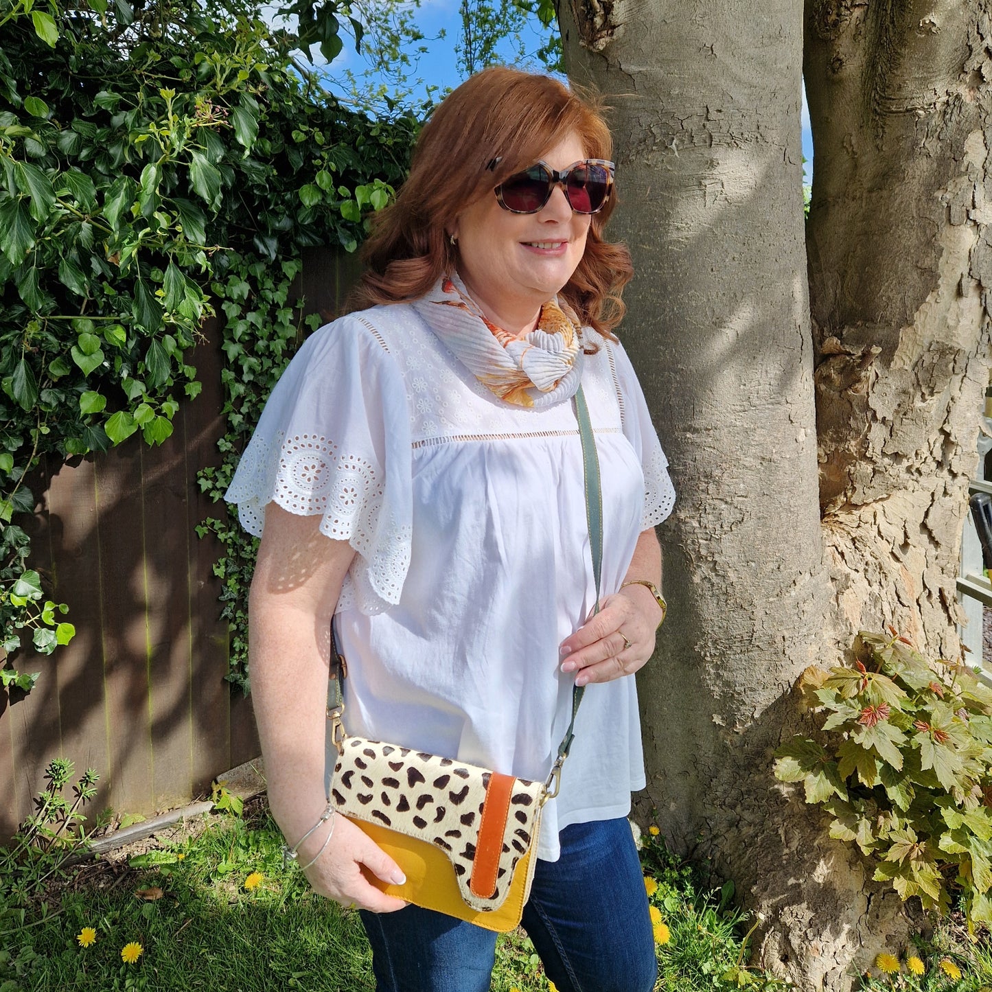 Lady wearing a yellow leather cross body bag.