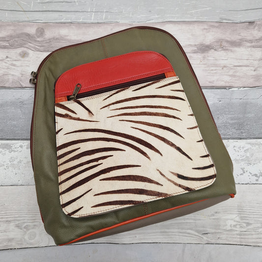 Olive green leather backpack with a large front pocket panel in zebra print.